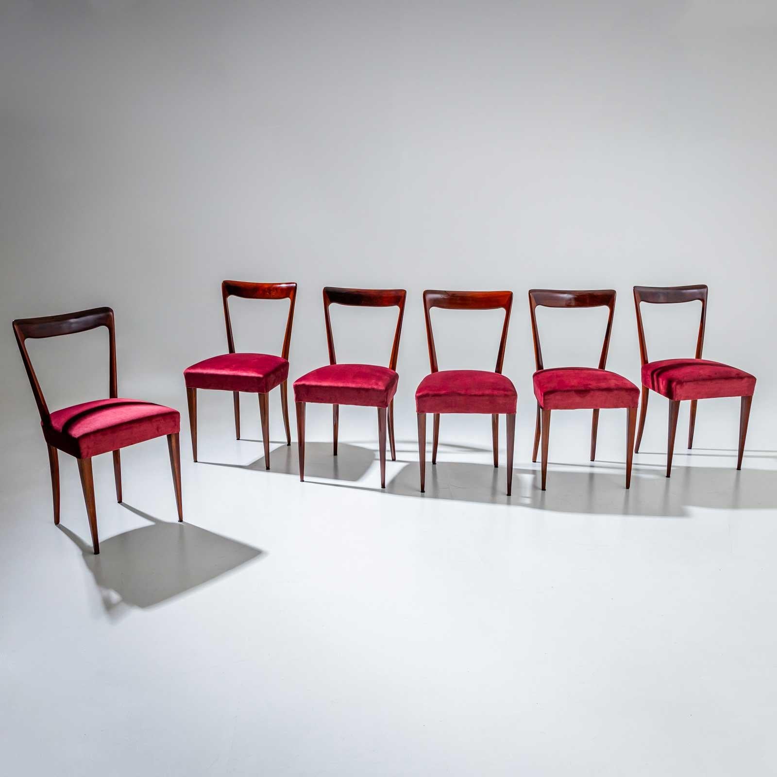 Ensemble de six chaises d'appoint avec d'élégants dossiers trapézoïdaux. Les chaises reposent sur des pieds coniques et ont été retapissées en tissu de velours rouge et polies.