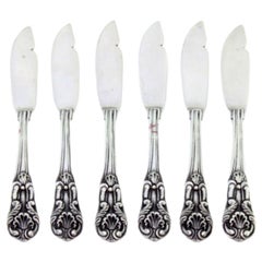 Set of six silver butter knives with reliefs and grooves along the handles