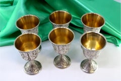Set of six silver chalices with chiseled reliefs and gold interior