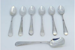 Set of six silver coffee spoons and sugar shovel with crimped handles