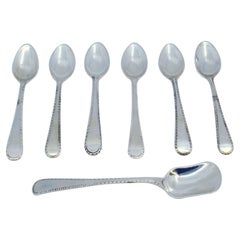 Set of six silver coffee spoons and sugar shovel with crimped handles