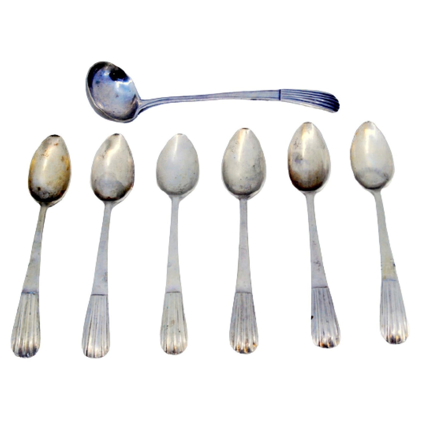 Set of six silver coffee spoons and sugar shovel with reliefs on the handles