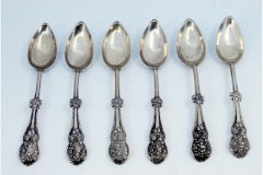 Set of six silver dessert spoons with trim and shells on the handle