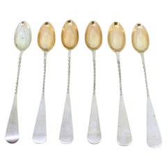 Set of six silver ice cream scoops with twisted handles and gold shells