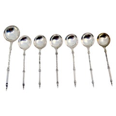 Set of six silver teaspoons and sugar ladles with twisted and raised handles