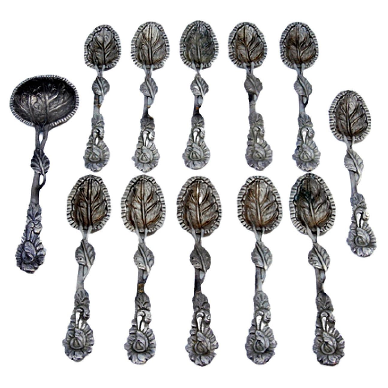 Set of six silver teaspoons and sugar shovel with embossed leaves