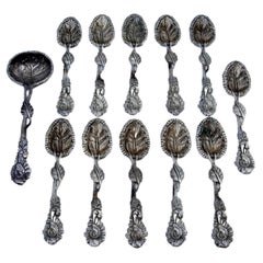 Set of six silver teaspoons and sugar shovel with embossed leaves