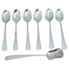 Ensemble de six cuillères à café et pelle à sucre en argent avec poignées en relief.