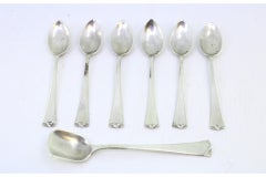 Set of six silver teaspoons & sugar scoops w/ reliefs on the ends of the handles