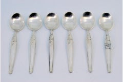 Set of six silver teaspoons with floral motifs and trim on the handles