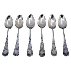 Set of six silver teaspoons with raised scrolls on the handles
