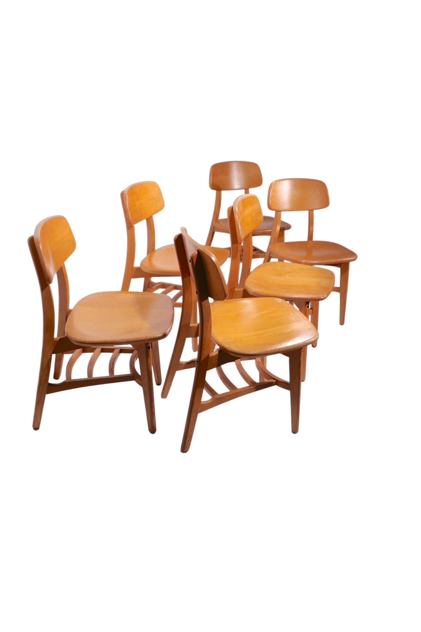 Set of six architectural mid century modern dining chairs, constructed of solid wood, probably maple, in original blonde finish. Executed in the style of Thonet, or Heywood Wakefield, these chairs were built to commercial standards, and will