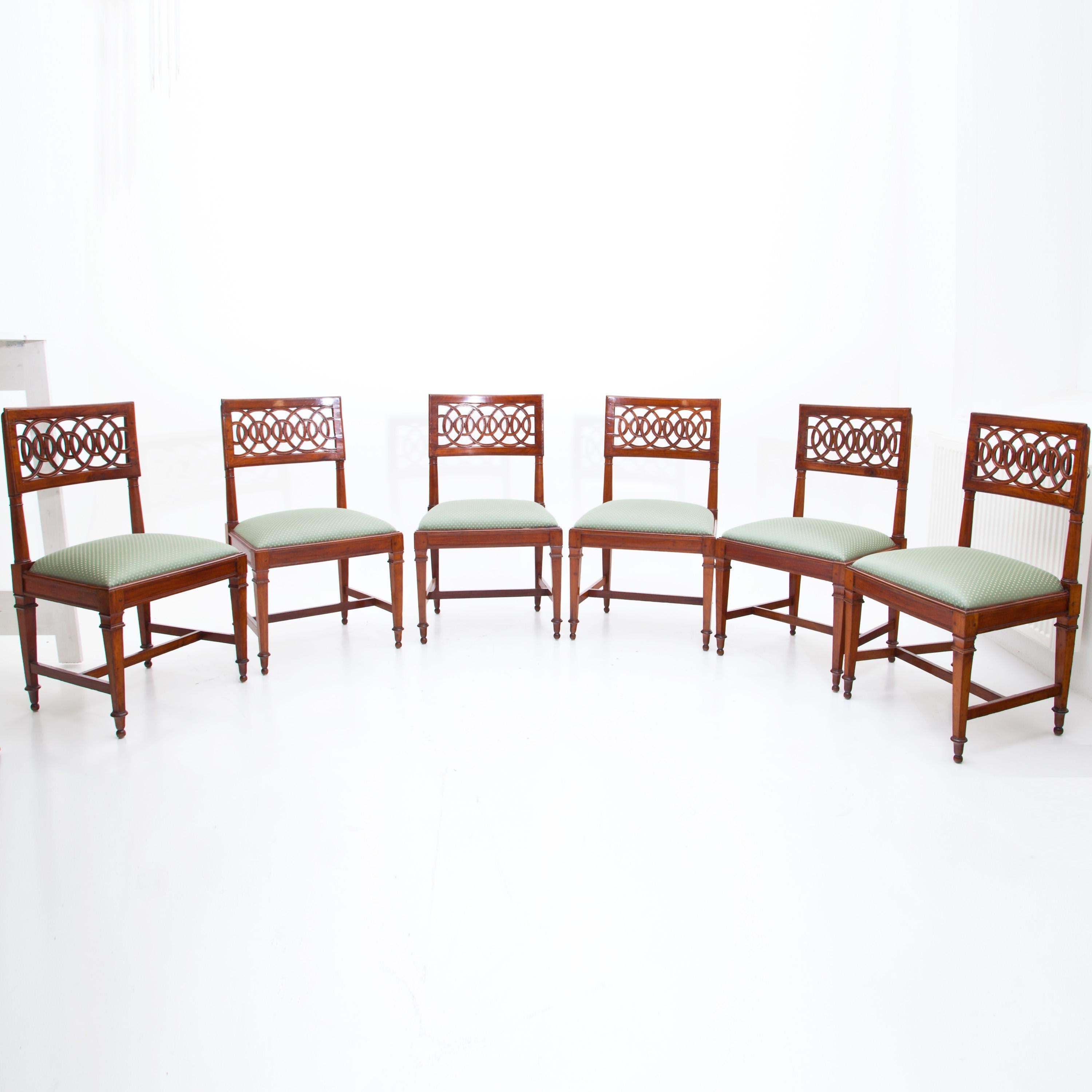 Late 18th century Lucca chairs made of solid cherrywood with upholstered seat cushions and circular openwork backrest. The seats are upholstered with a high-quality green fabric with golden fleur-de-lis decor.
 