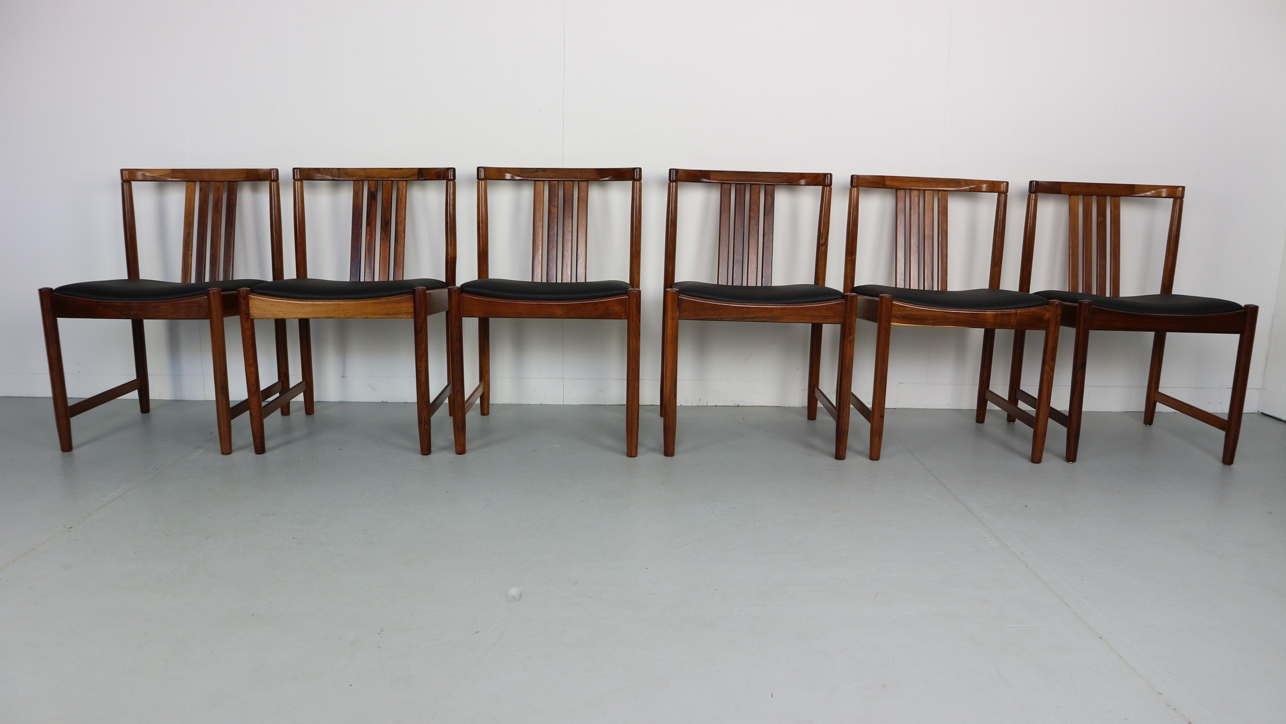 Set of six dining chairs made of solid rosewood and black skai leather seating.
 