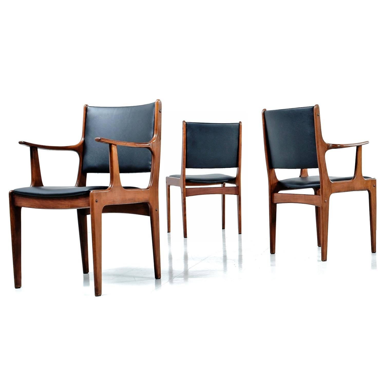 Set of six solid teak vintage Danish modern dining chairs made in Singapore. The seats have been updated with new high quality black vinyl upholstery. The stout construction suits today's needs, enhancing comfort without sacrificing styles.