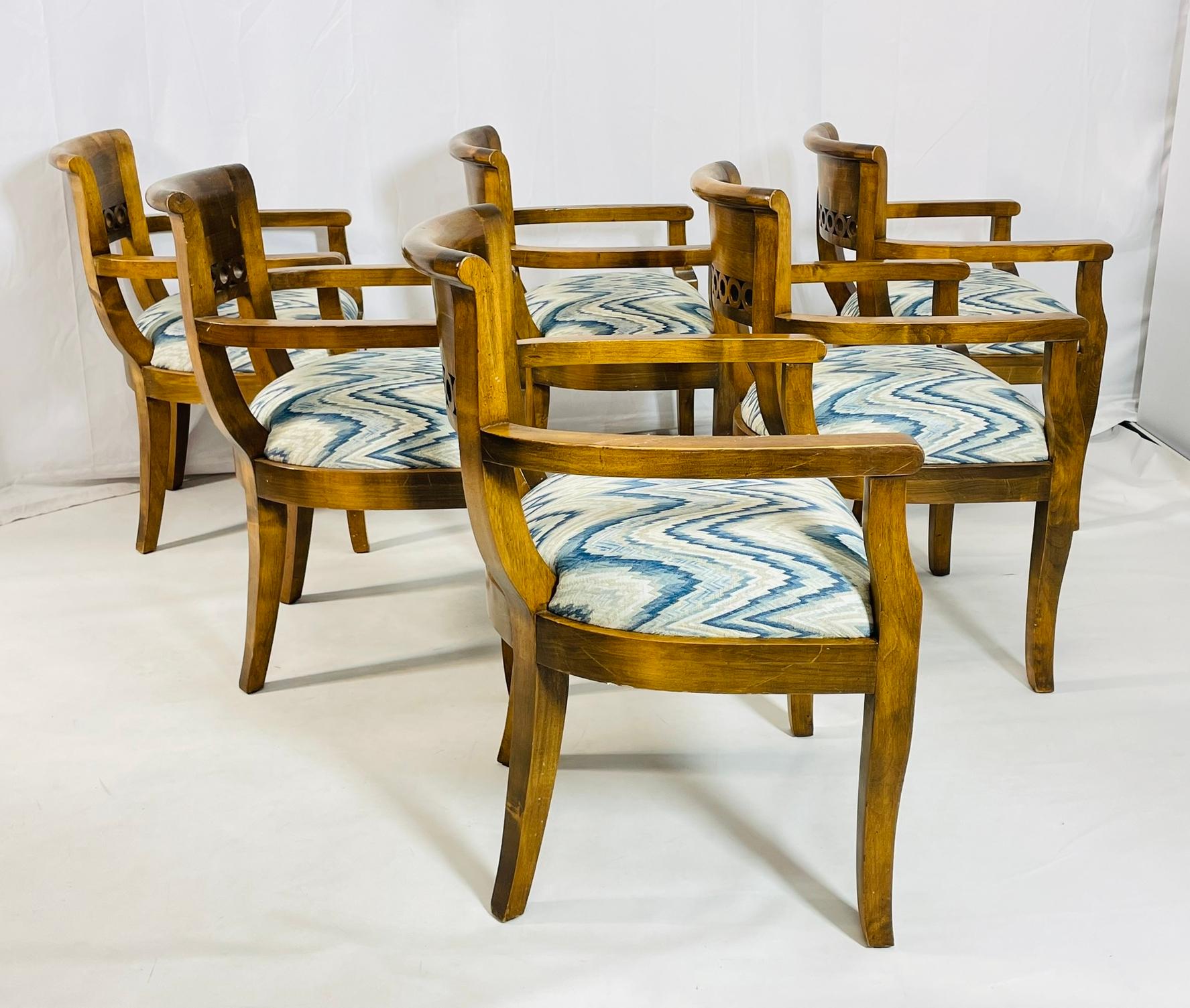 Set of six vintage dining chairs designed and manufactured in the United States in the 1970s.

The chairs are made out of solid wood, they all have arms and they are upholstered in zig-zag patterned fabric.

The chairs are very comfortable, the