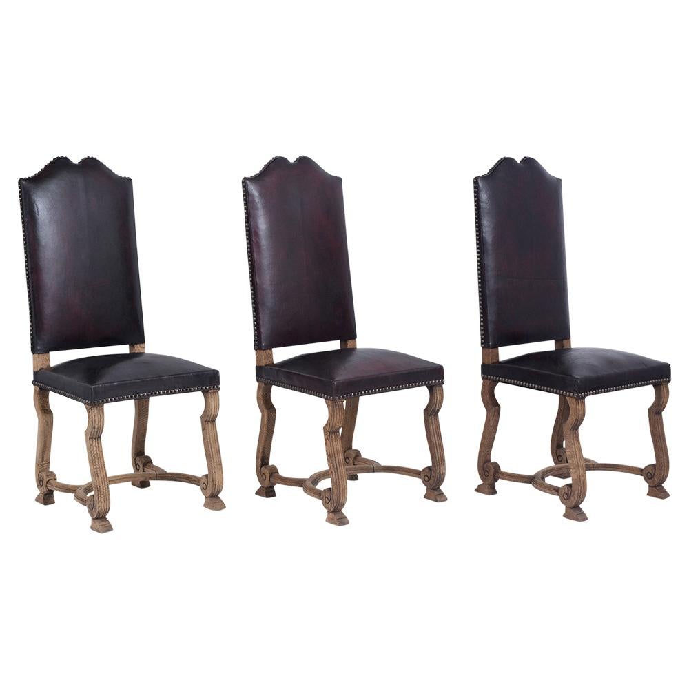 Cet ensemble de six chaises à manger anciennes de style espagnol a été récemment remis à neuf. Il est fabriqué en bois de chêne massif avec un beau design sculpté:: et est recouvert de cuir nouvellement teint dans une couleur bordeaux foncée. Ces