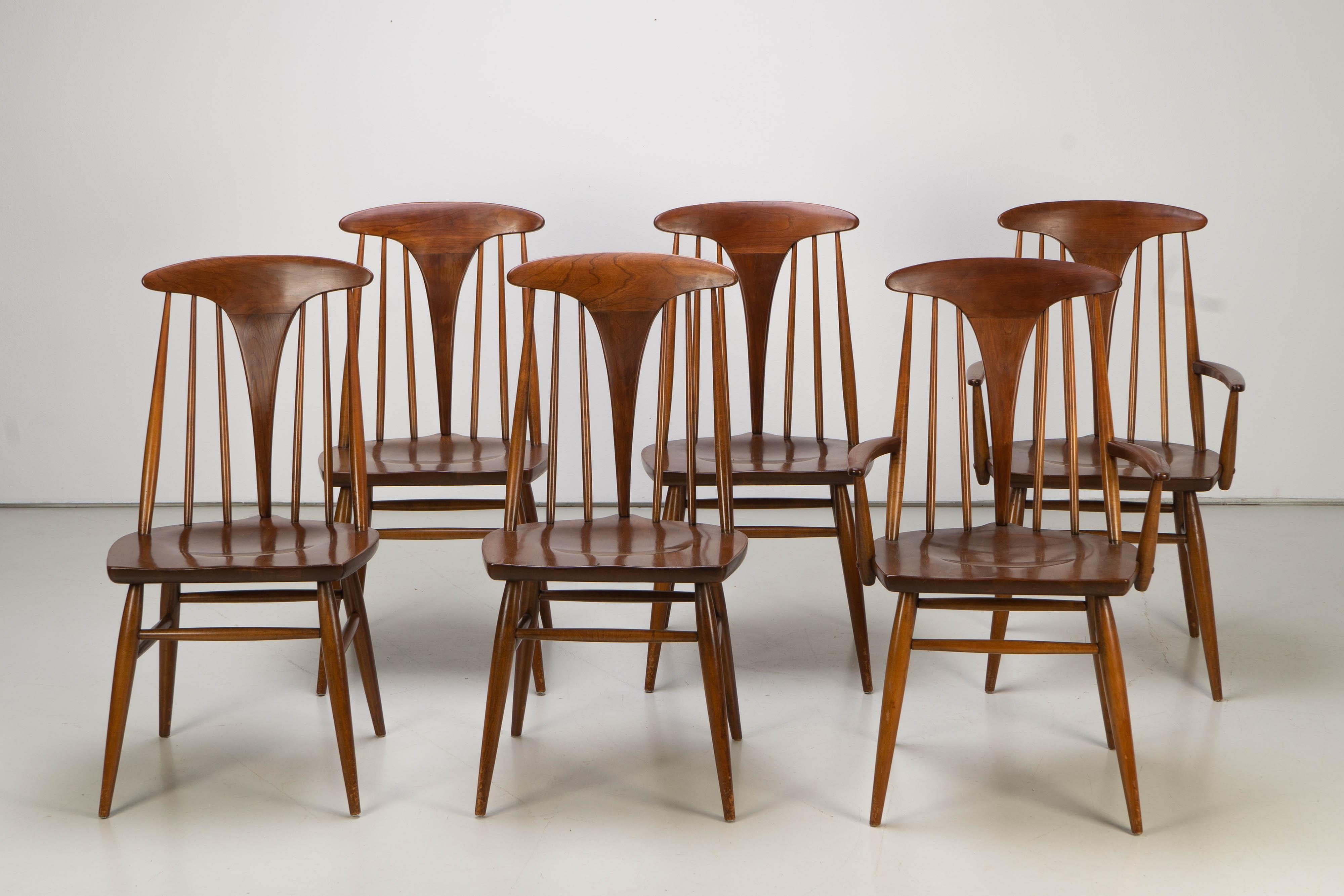 Set of six Mid-Century Modern spindle back chairs manufactured by Heywood Wakefield. The chairs have been made with American walnut, featuring beutiful details. 
Sidechairs are 50 cm wide, arm chairs 58 cm.