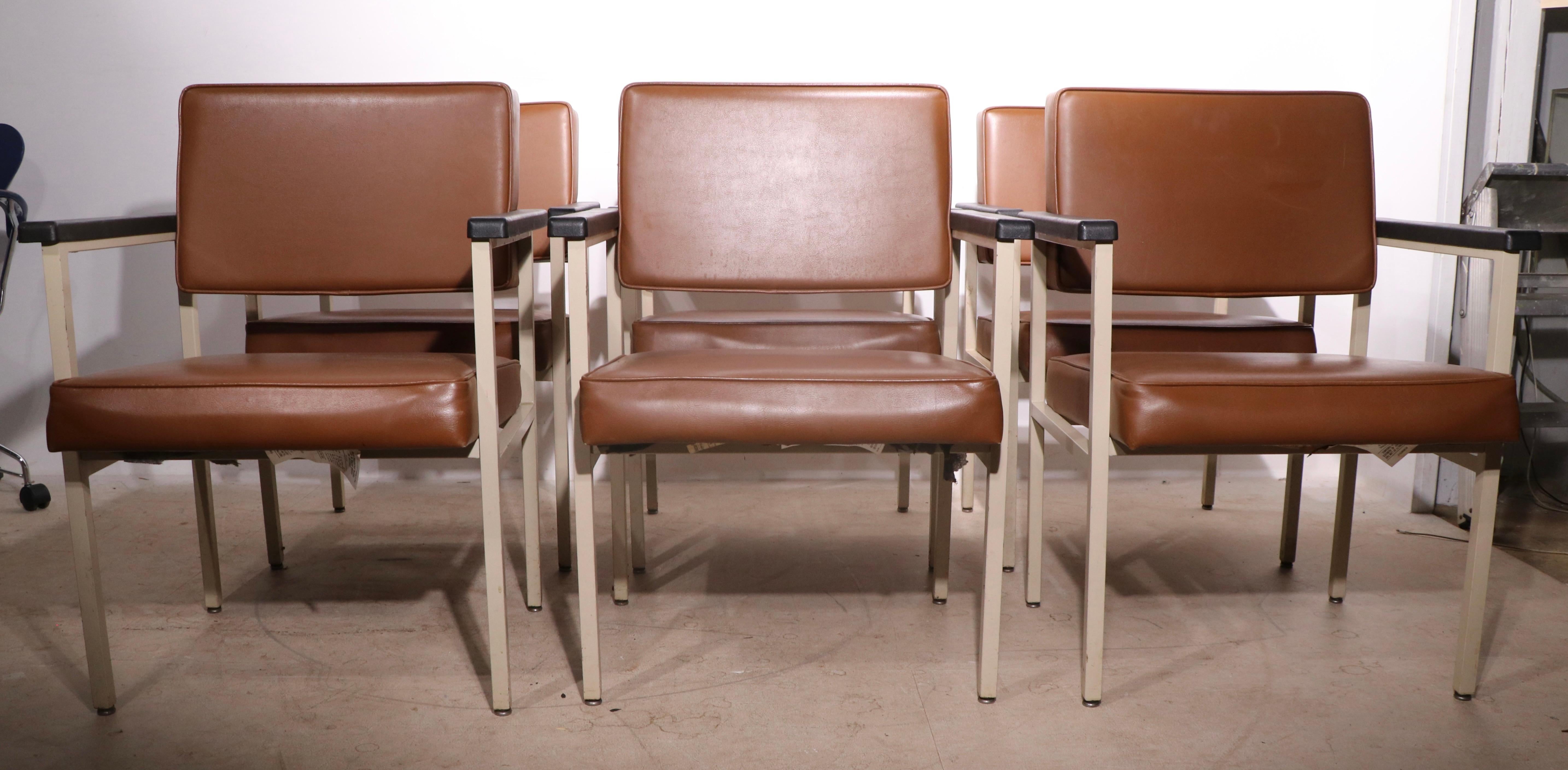 Chic architectural design set of dining height arm chairs by noted American furniture manufacturer, Steelcase. The chairs feature a padded backrest and seat cushion in brown vinyl, on squared steel frames, in original tan finished steel frames with