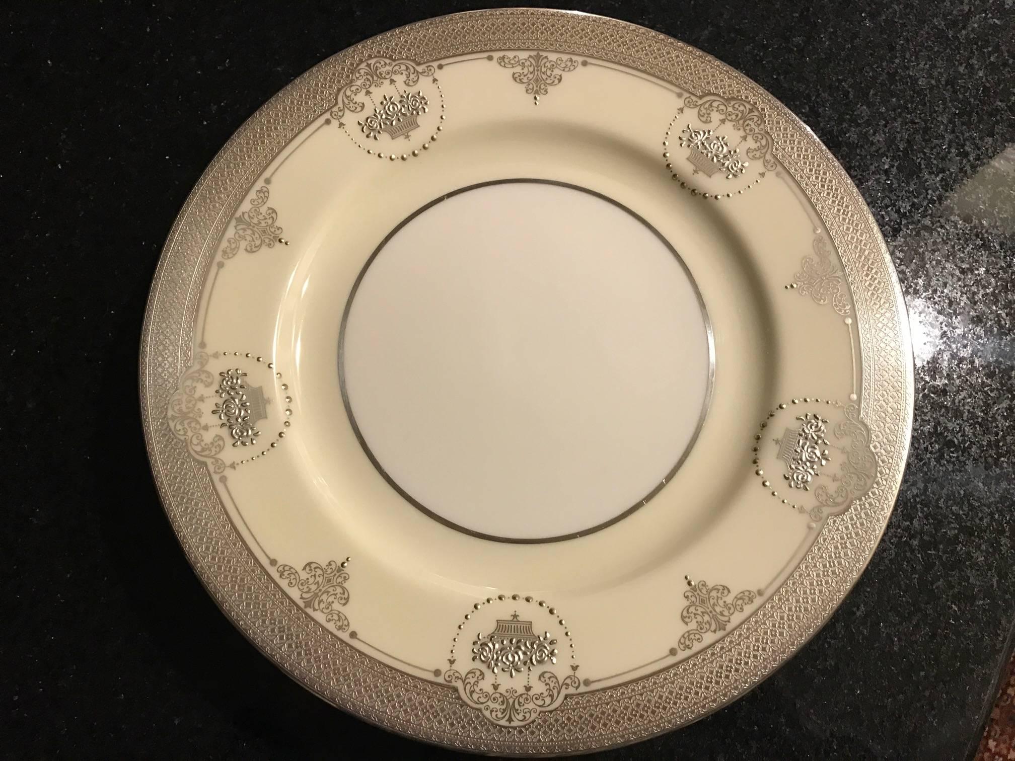 Un ensemble d'élégantes assiettes de service en argent sterling superposé avec la marque verte Lenox d'avant 1930. Cette opulente parure du début du XXe siècle, vers 1915, présente un motif édouardien composé d'une épaisse bande en sterling et d'un