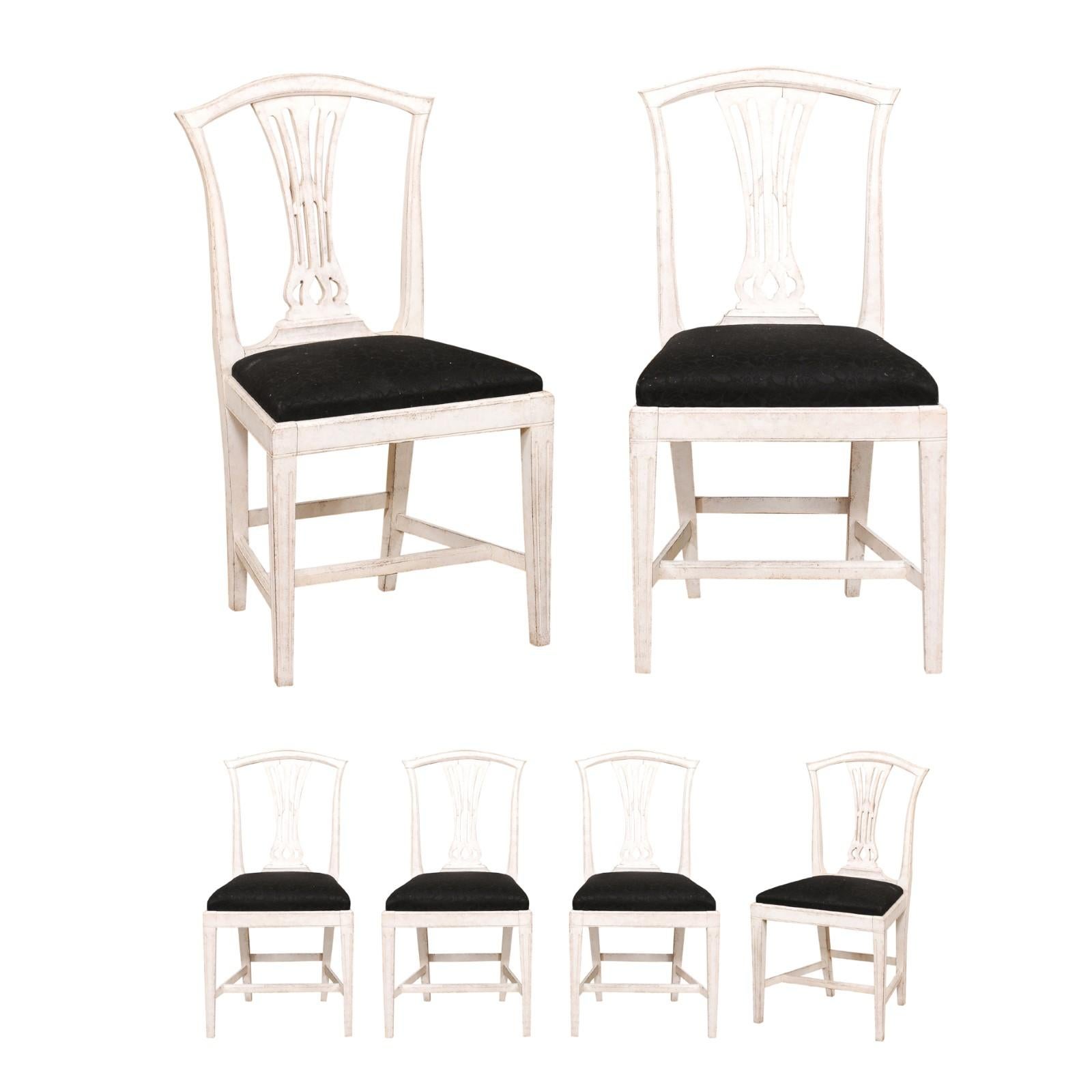 Ein Satz von sechs schwedischen Esszimmerstühlen aus bemaltem Holz aus dem späten 19. Jahrhundert, mit geschnitzten Leisten, spitzen Beinen und schwarzer Polsterung. Dieser Satz von sechs bemalten Stühlen wurde im letzten Jahrzehnt des 19.
