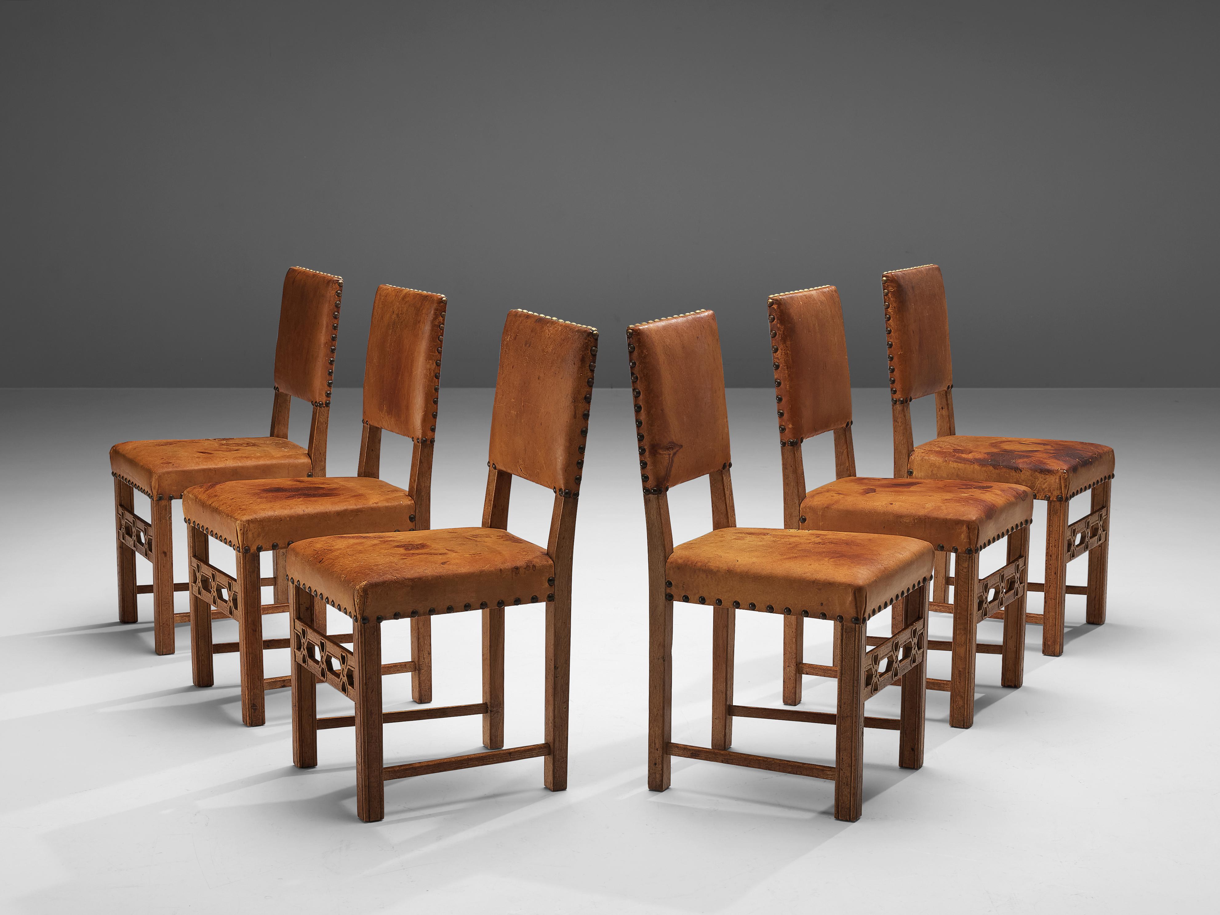 Set of six dining chairs, oak, patinated, leather, Sweden, 1940s

Set of six elegant dining chairs in oak and expressive patinated cognac leather. The leather is fixed to the frame with big brass nails which add an art deco appeal to the design.