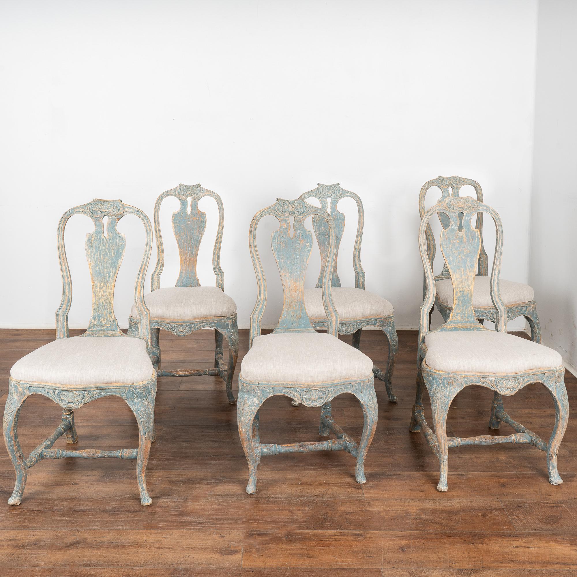 Set of 6 lovely Swedish rococo dining chairs with curved cabriolet legs and carved accents. 
Newer professionally applied custom layered blue painted finish with white undertones has been lightly rubbed and perfectly distressed to fit the age of