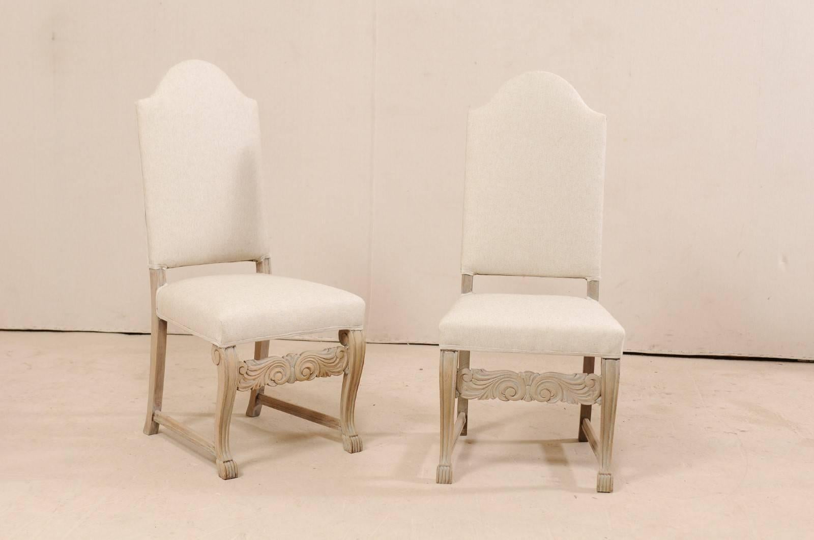 A set of six Swedish upholstered and carved wood side chairs. These vintage chairs from Sweden each feature upholstered camel (or convex arch) seat backs, upholstered seats, carved front legs with scrolled knee backs and claw feet, and an ornately