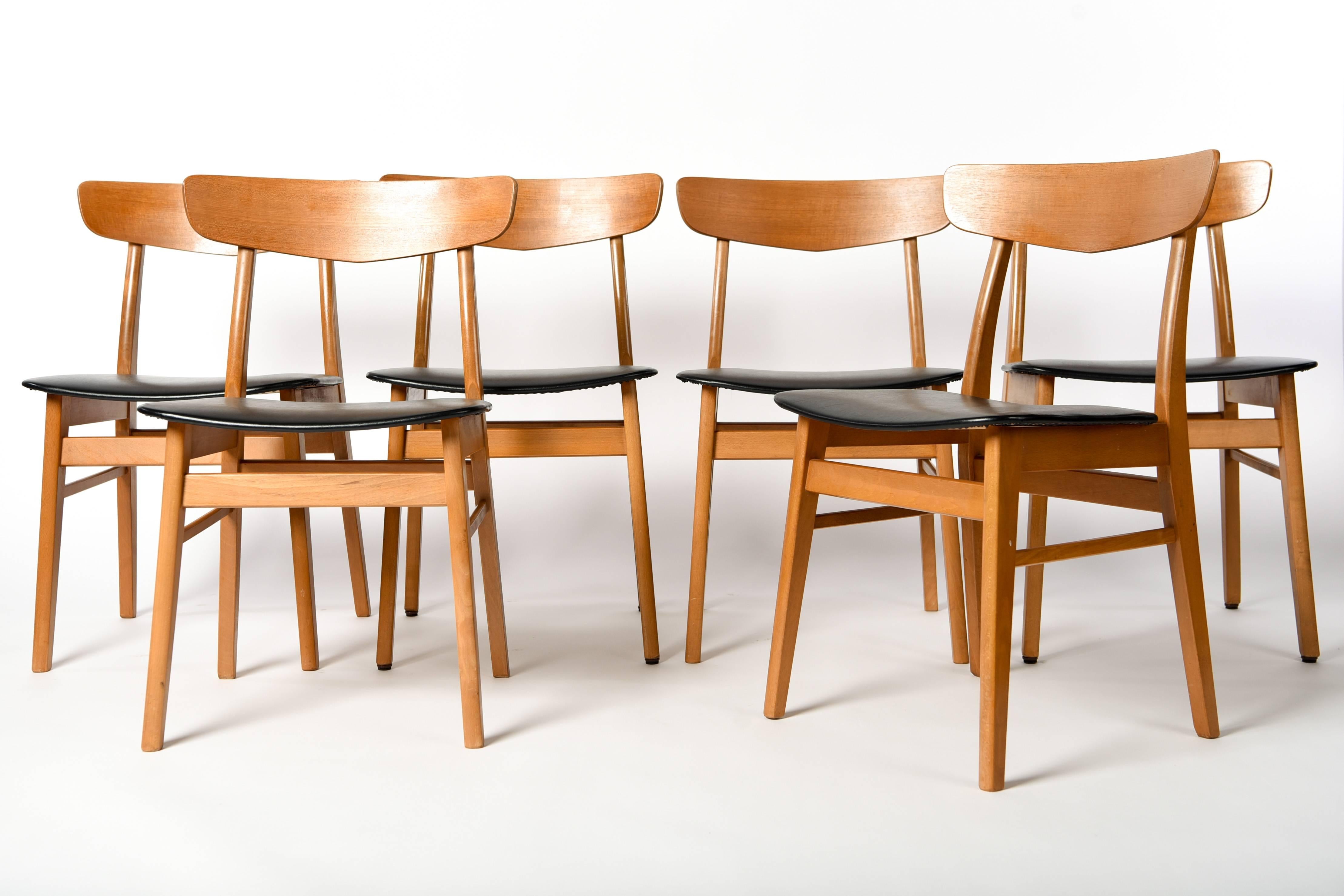 This is a set of six dining chairs made by SAX, circa 1960. Great Danish midcentury design. Featuring Classic teak frames with black seats, these chairs have a versatile appearance.