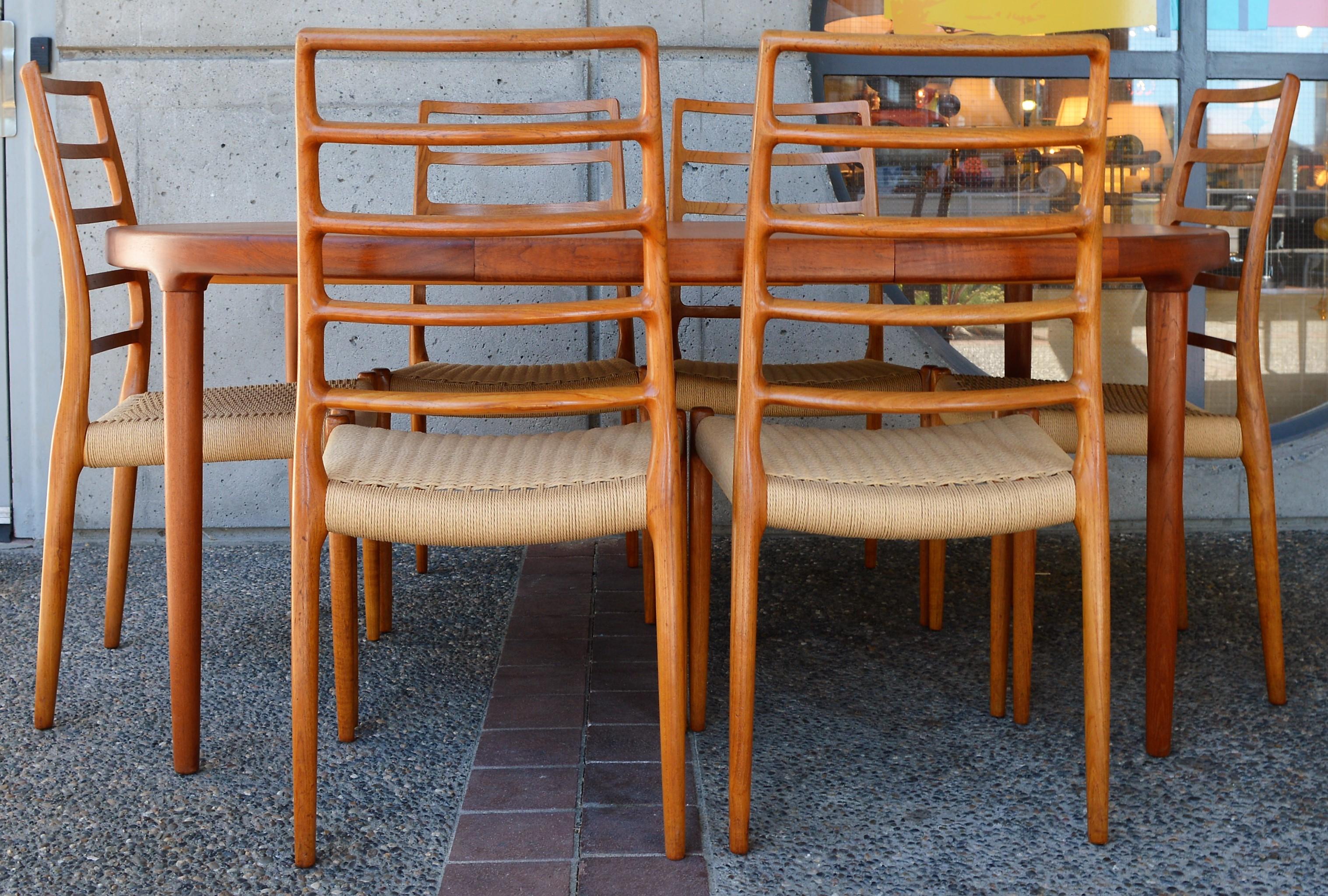 This rarely seen set of six Danish modern teak sculptural dining chairs by Niels Otto Moller for J.L. Moller are the taller five rung ladder back chairs - model 82. The wood is freshly oiled, the frames tight, and the seats newly strung with Classic