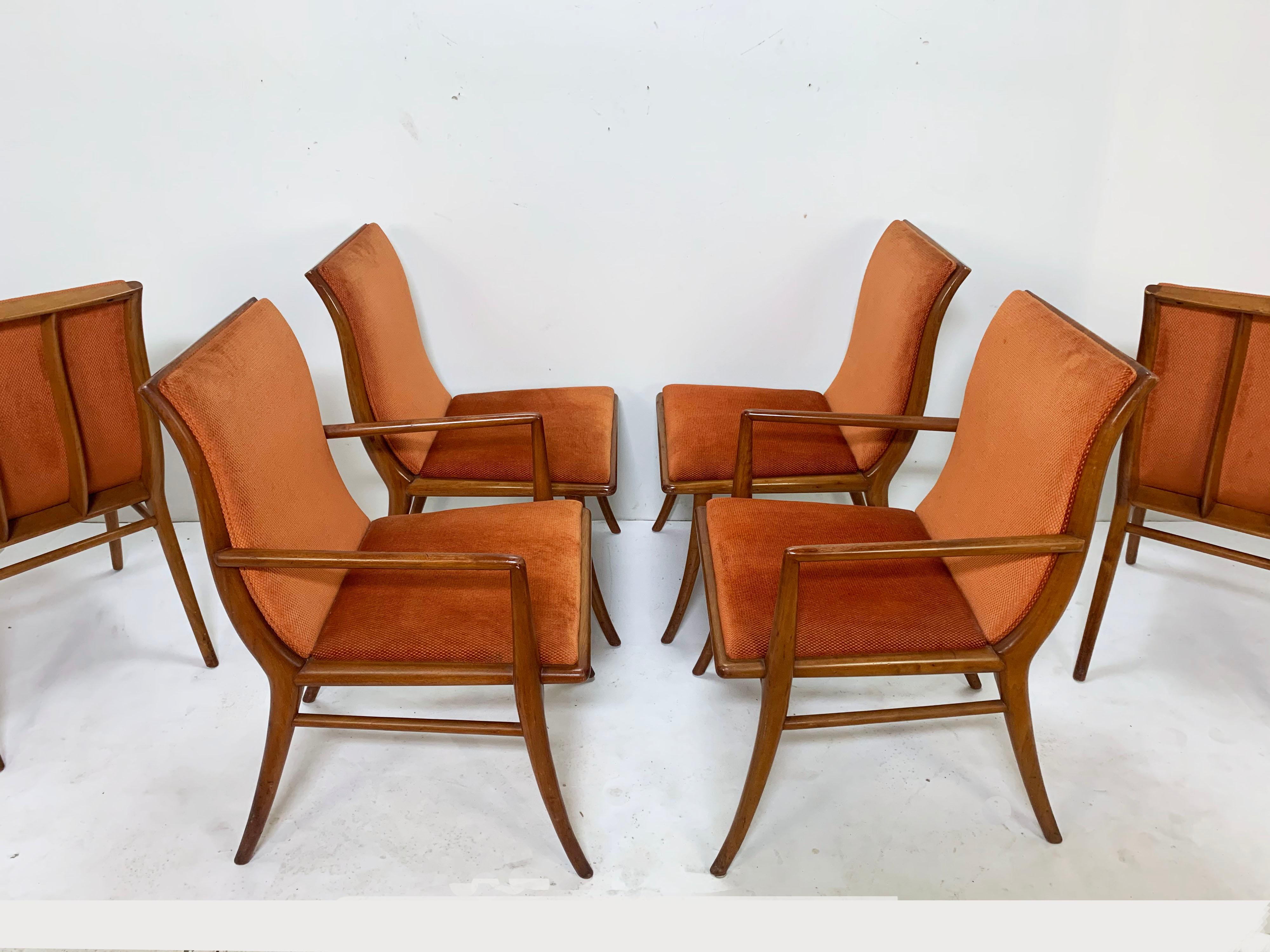 A set of six saber leg dining chairs in walnut with upholstered seats and backs, two arm and four sides, model no. 4204, designed by T.H. Robsjohn Gibbings for Widdicomb, circa late 1940s.

Armchairs measure 22.5” wide x 24” deep x 33.5” high,