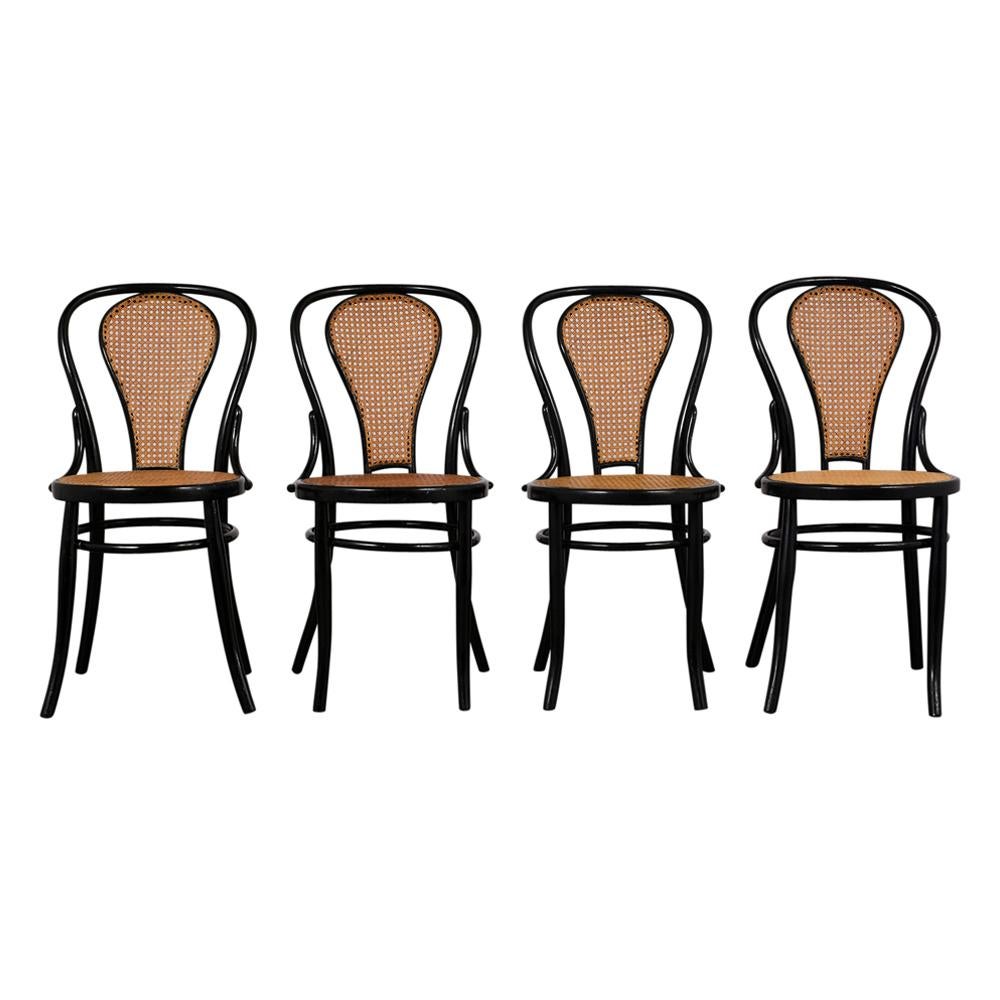 This Set of Six Thonet Bentwood Fauteuil No. 11 Dining Chairs has been fully restored and feature curved bentwood frames with a beautiful ebonized lacquered finish. The chairs have cane webbing on the back/seat rests in good condition and are sturdy