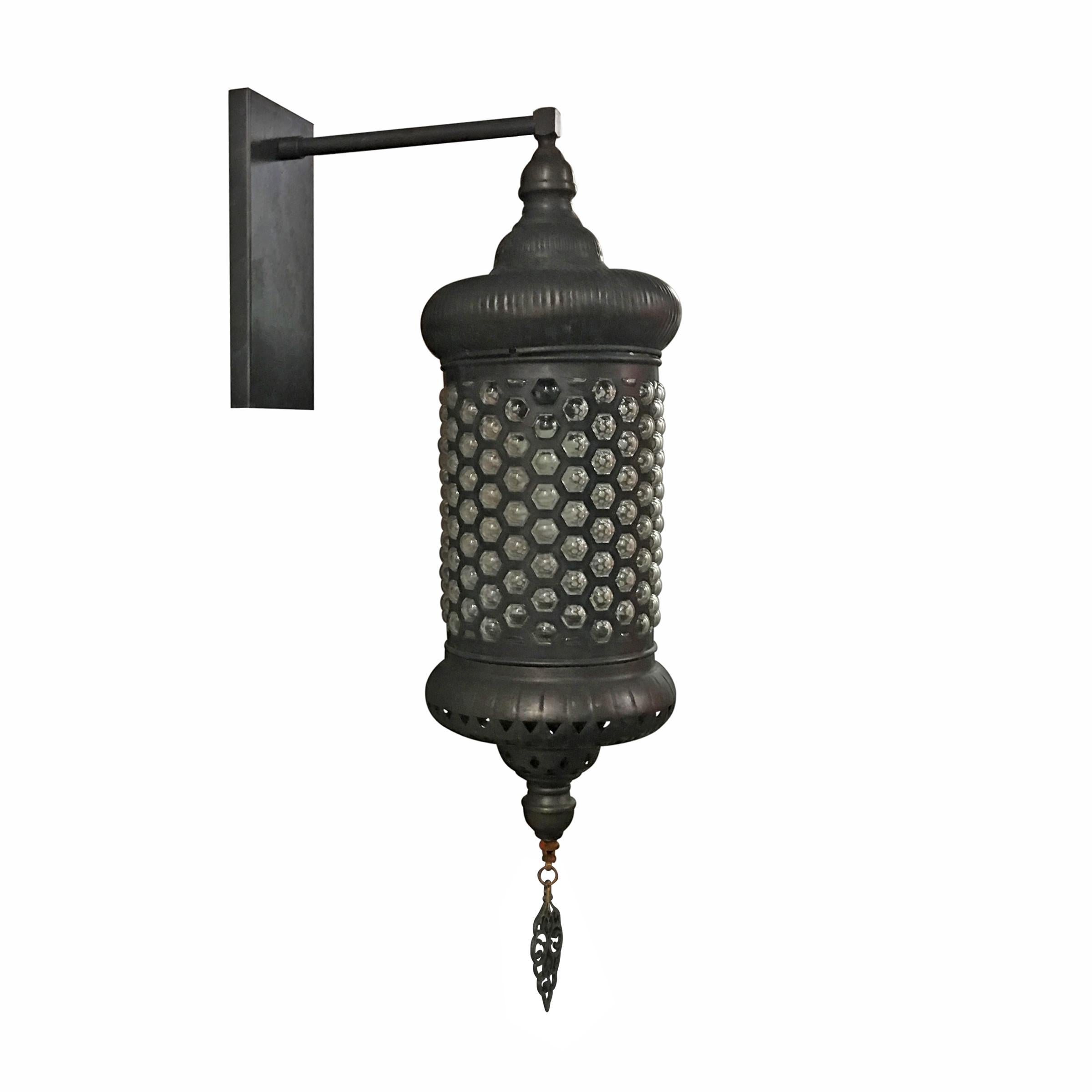 An incredible set of six Turkish rolled steel lantern-form sconces with hand blown bubble glass shades, each with a metal cartouche hanging from the bottom. These sconces were once installed in an outdoor courtyard and have a wonderful patinated