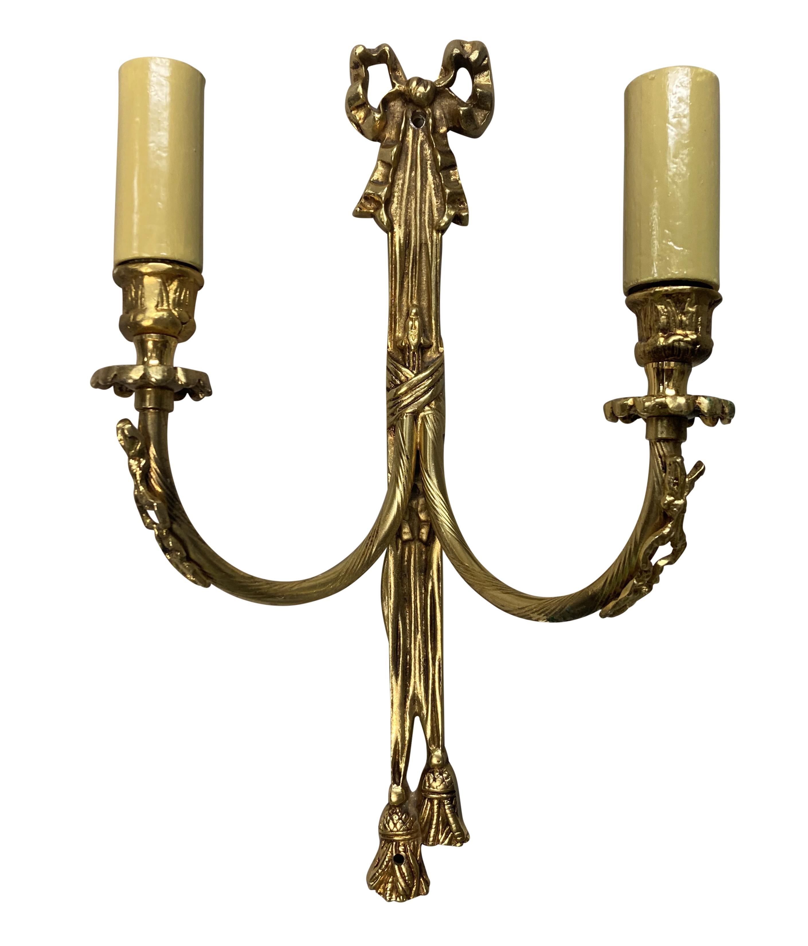 A set of six English twin branch wall lights in brass, with bows, tassles and swags.