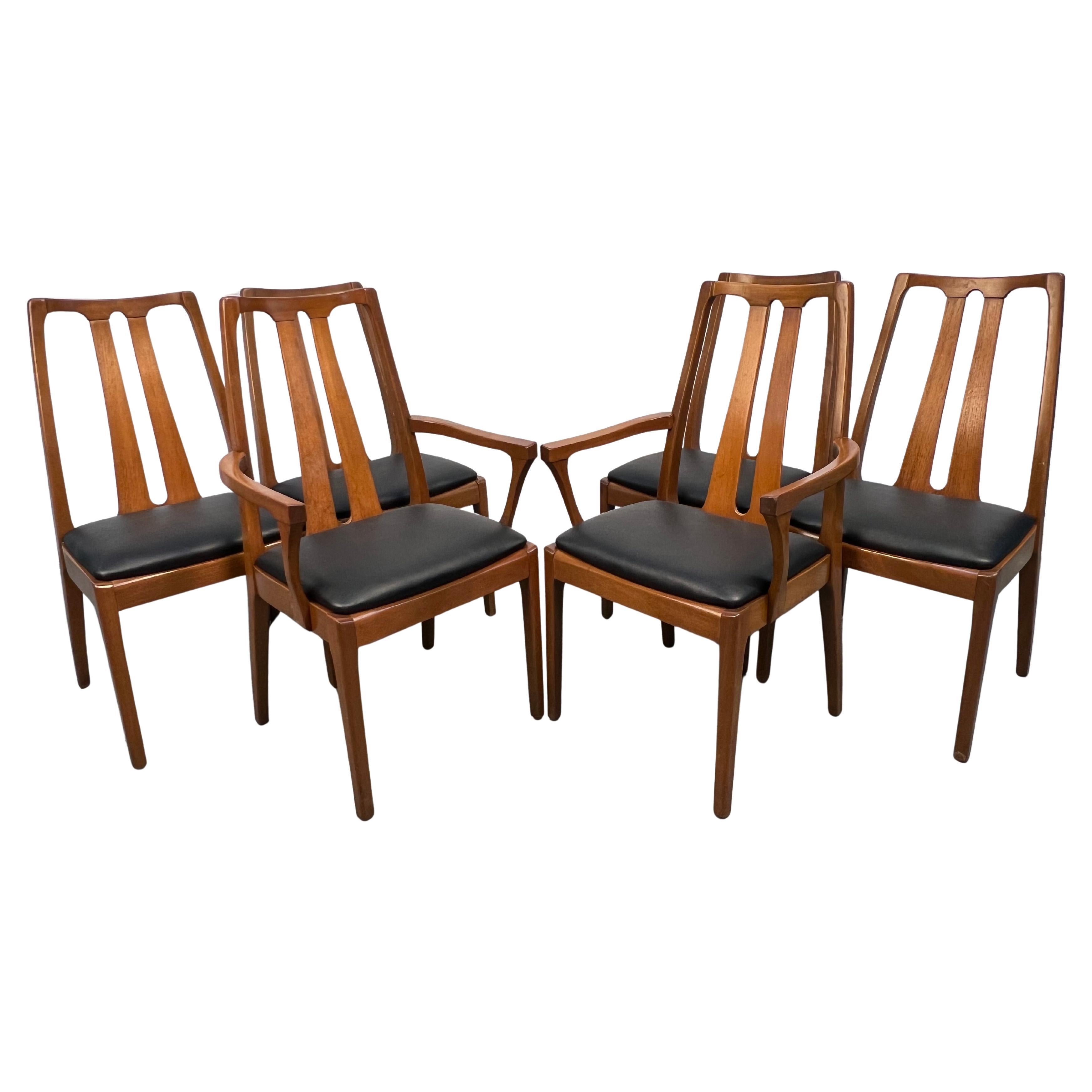 Un conjunto clásico de seis sillas de comedor danesas, fabricadas en nogal con vetas cálidas y elegantes. Las líneas limpias y la forma escultural reflejan el diseño intemporal de mediados de siglo, mientras que la tapicería se mantiene en