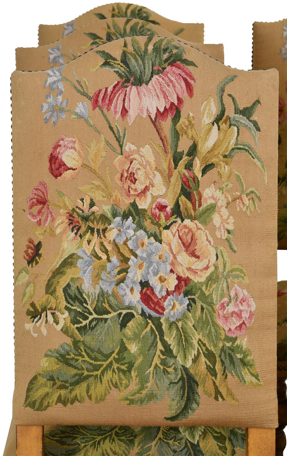 A set of six well-crafted dining chairs with high arched back and seat upholstered in a beautiful woven tapestry with a floral bouquet with foliage. Frame is of a light/medium colored hardwood with turned front legs, 