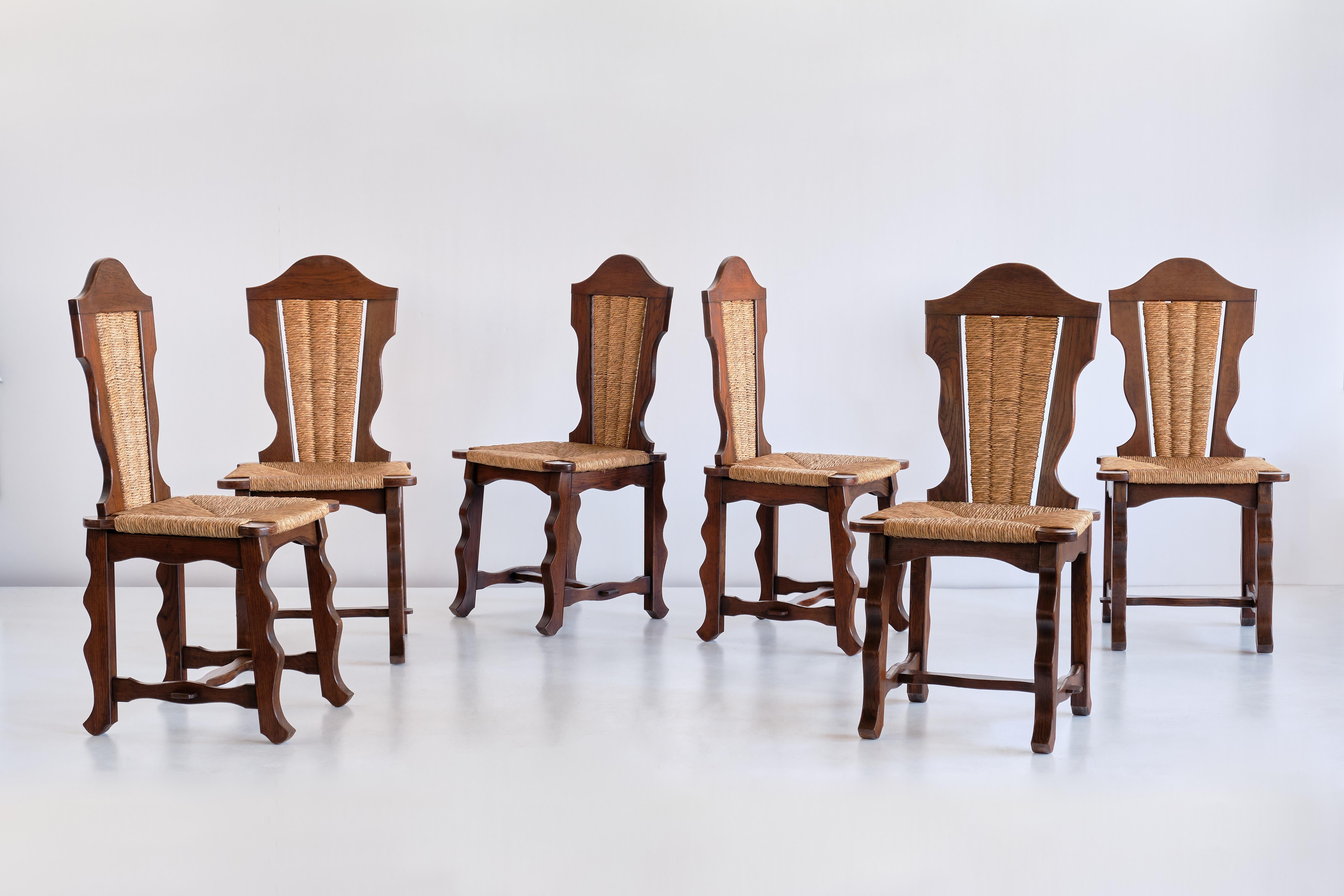 Ce remarquable ensemble de six chaises de salle à manger a été produit dans la région du nord du Pays basque, autour de la ville de Biarritz, dans les années 1950. Le dessin est attribué à Victor Courtray.
Les chaises sont en chêne massif teinté,