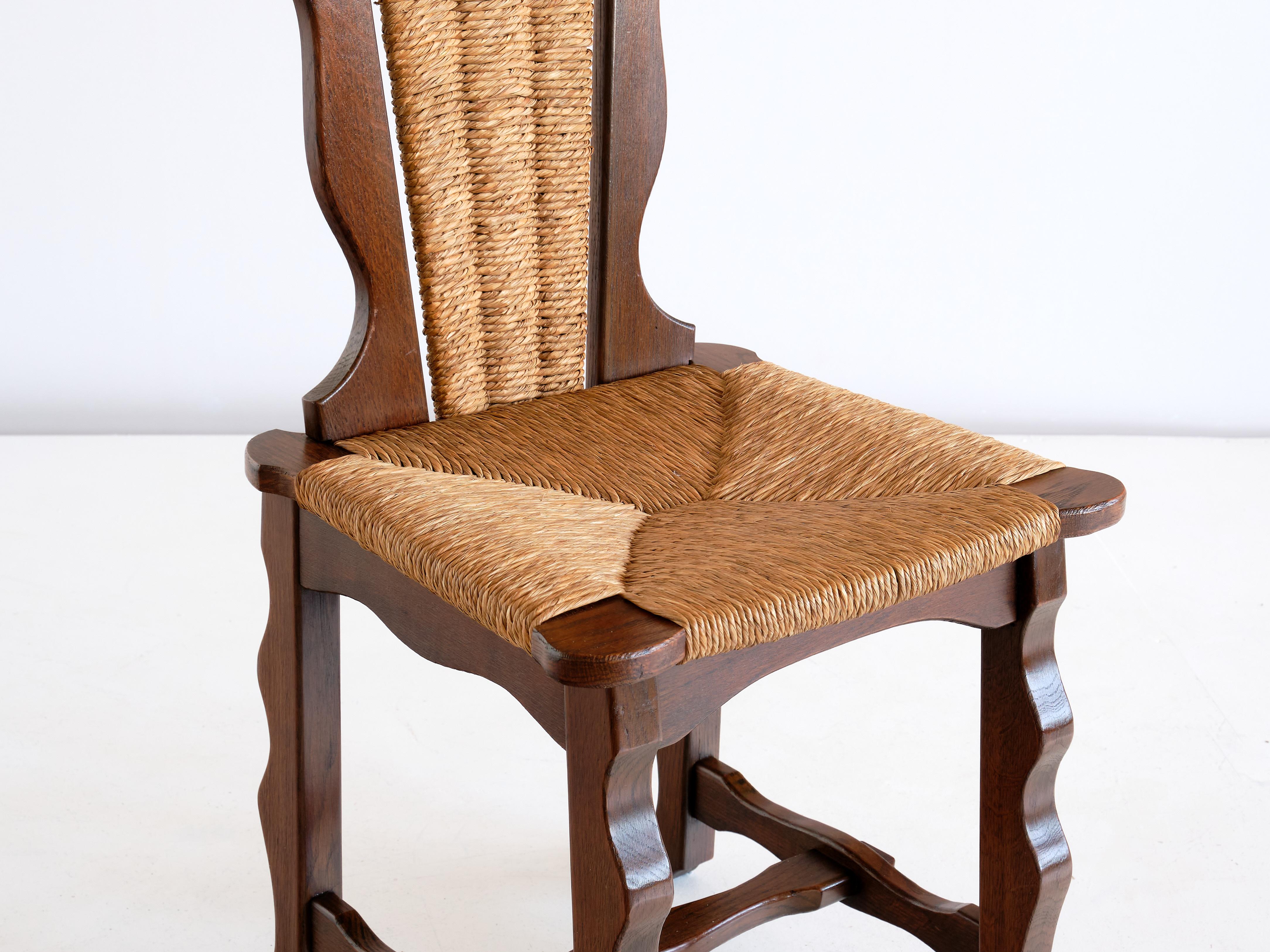 Milieu du XXe siècle Ensemble de six chaises de salle à manger en chêne et jonc attribuées à Victor Courtray, années 1950 en vente