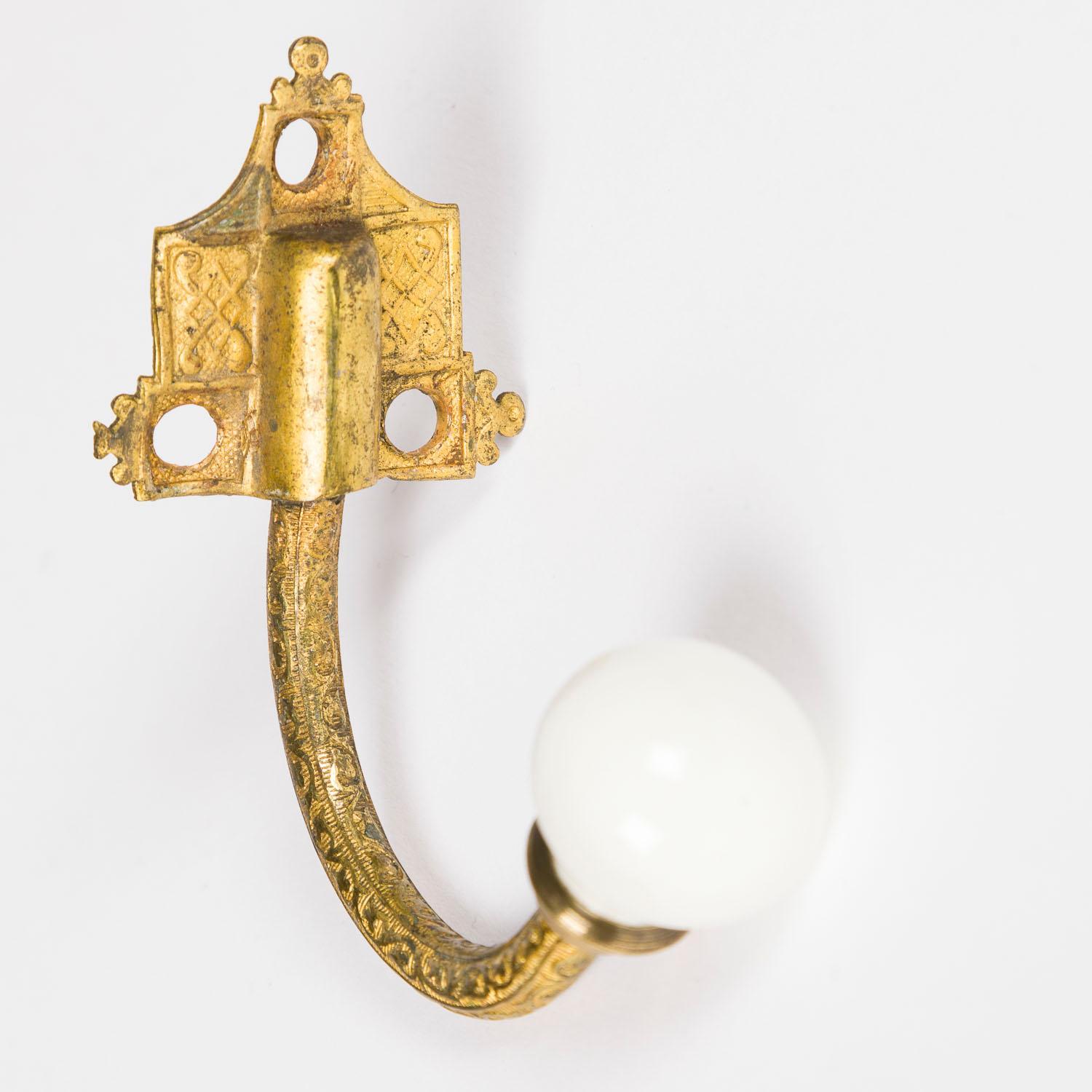 A set of six Victorian gilt brass and white porcelain coat hooks.
