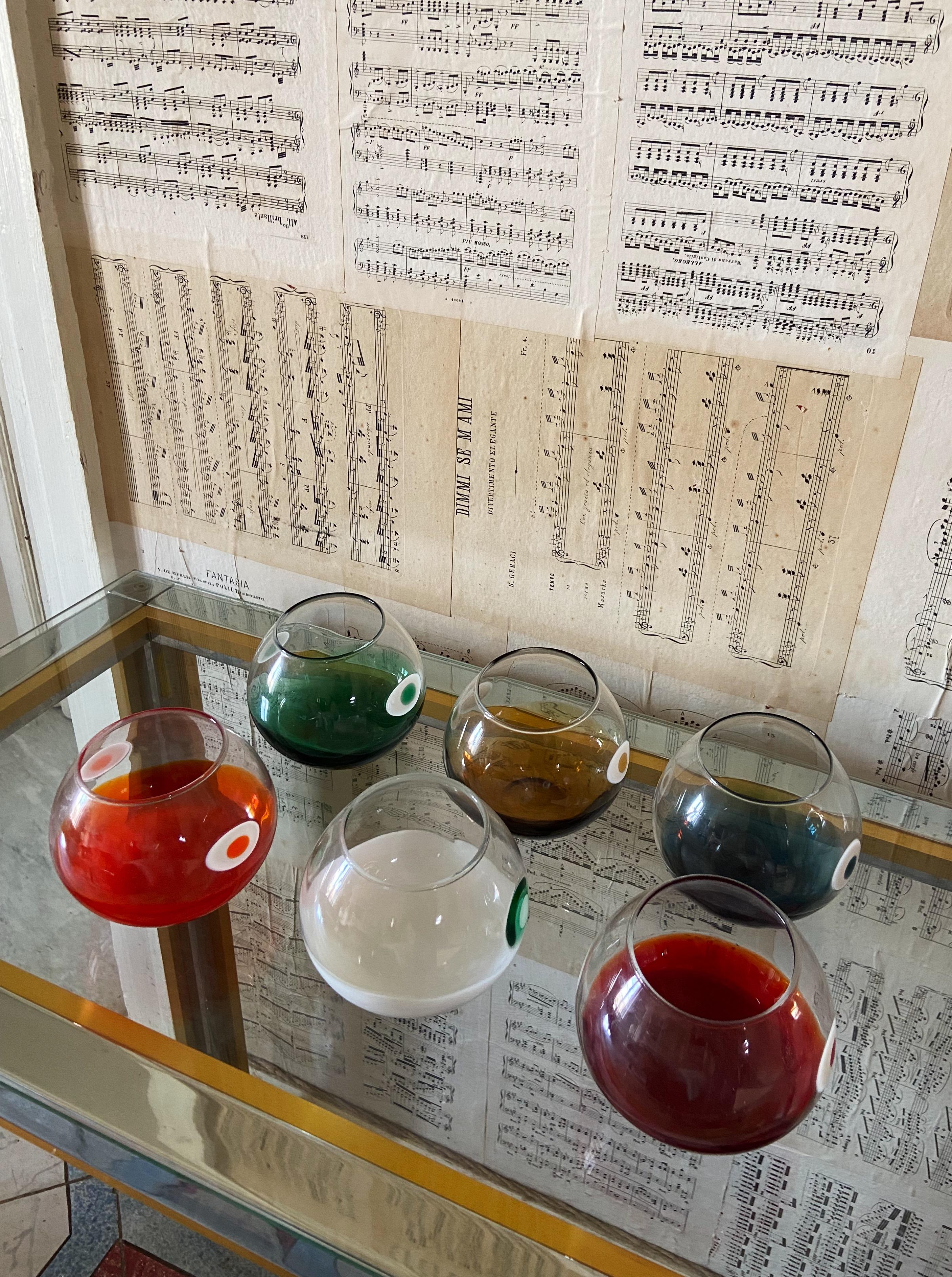 Impresionante juego de seis vasos de Murano, cada uno elaborado de forma única en un color vibrante diferente, lo que los convierte en una mezcla perfecta de arte pop y elegancia. Estos vasos, que datan de la década de 1970, muestran una exquisita