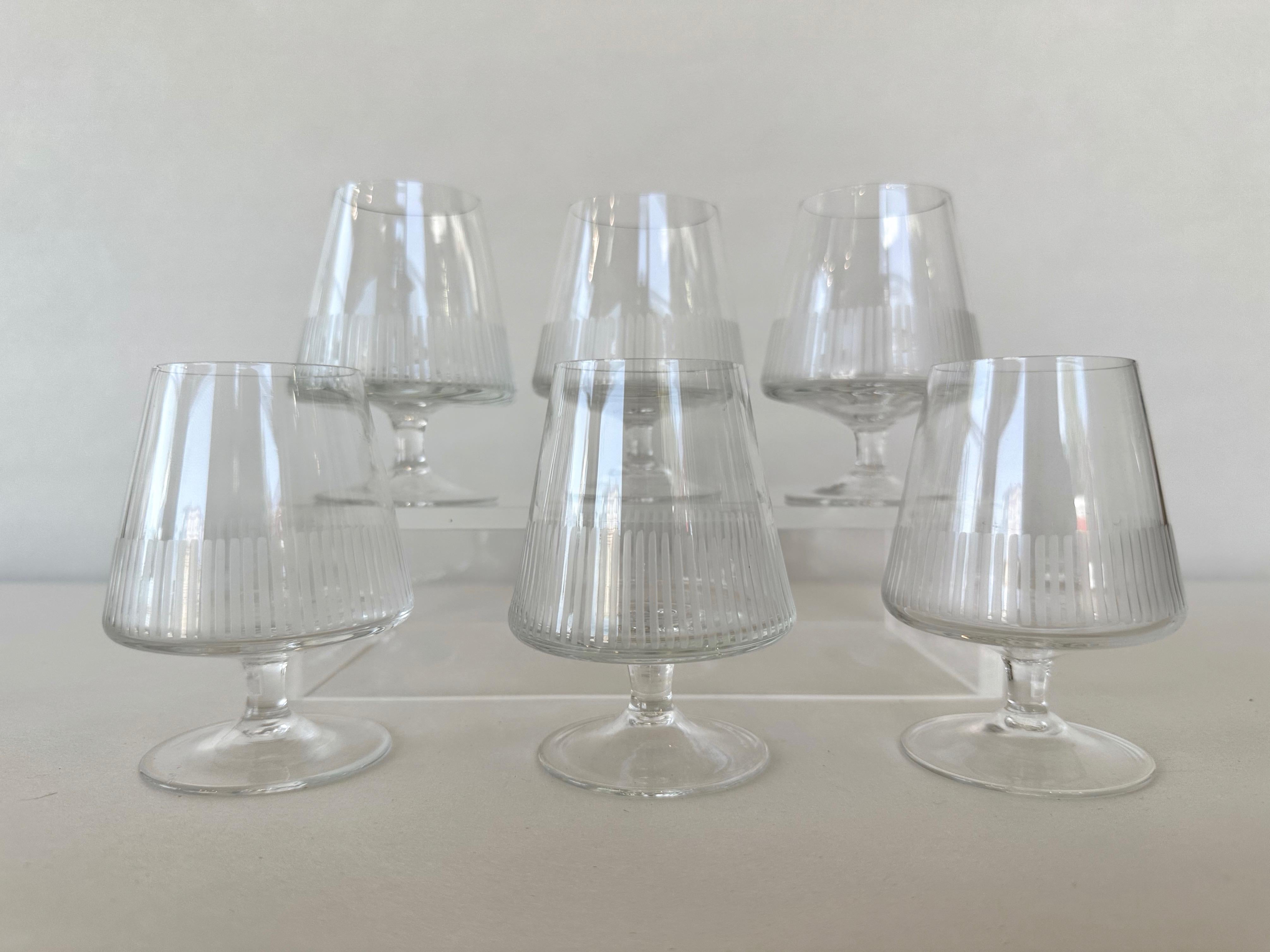 A 1950s six-piece set of etched crystal balloon glasses by Atlantis.

Perfectly proportioned crystal stemware featuring exactingly hand-etched vertical line detailing around the body. Specifically shaped to enhance the flavor and aroma of cognacs,