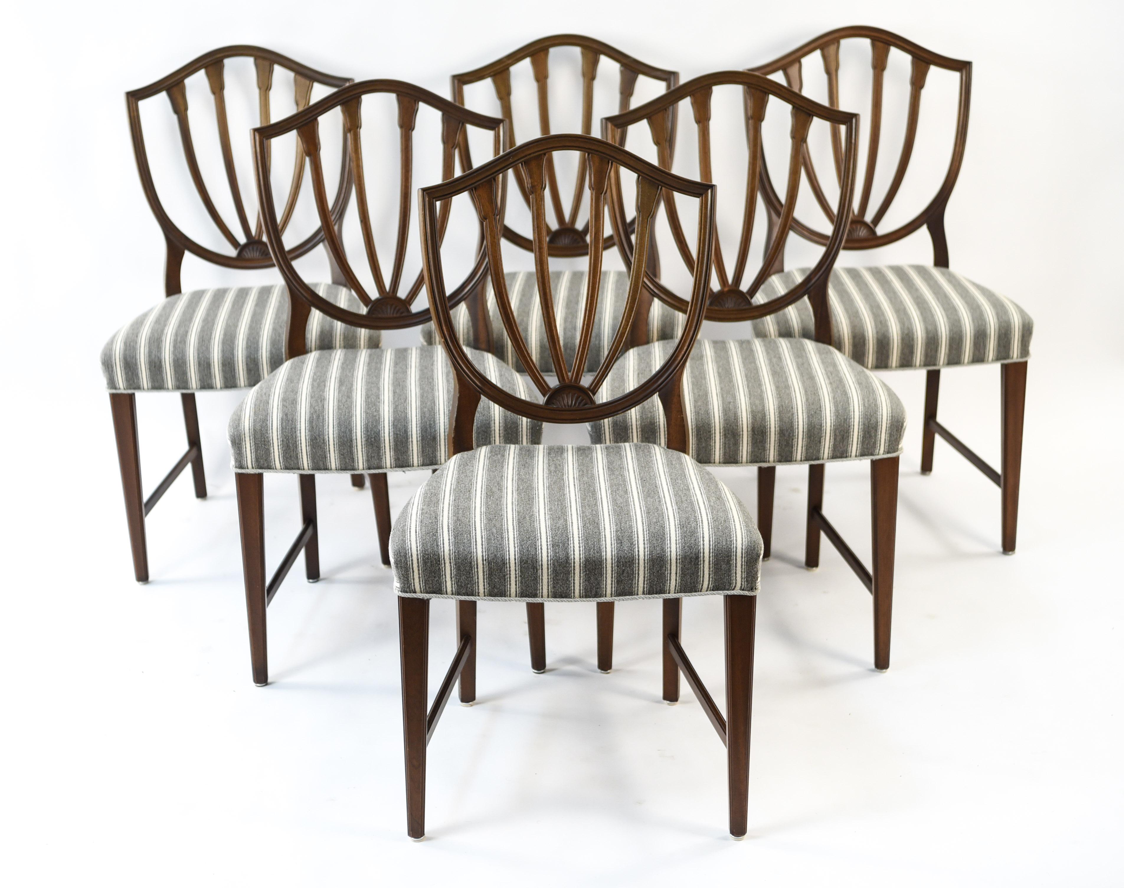 This is a beautiful vintage set of six English dining chairs in the Hepplewhite style featuring the characteristic shield back design. This set is a great way to incorporate a timeless design into a contemporary dining space.