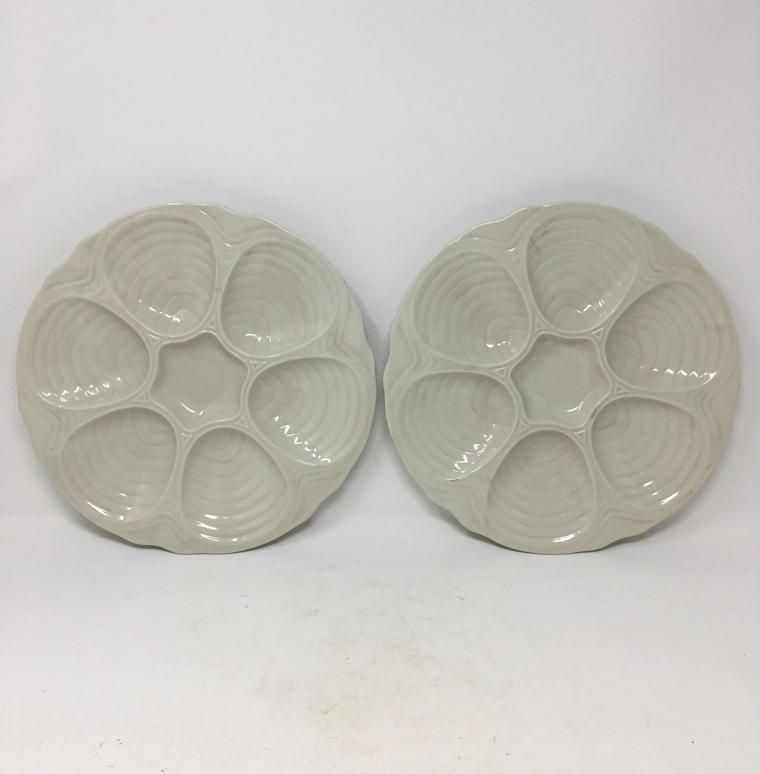 Set of six vintage Modernist ironstone oyster plates by Hall. Each plate is hallmarked on the underside hall, made in the U.S.A. 1151. Glazed in a creamy white, each plate is manufactured with six ribbed wells for serving raw oysters and a center