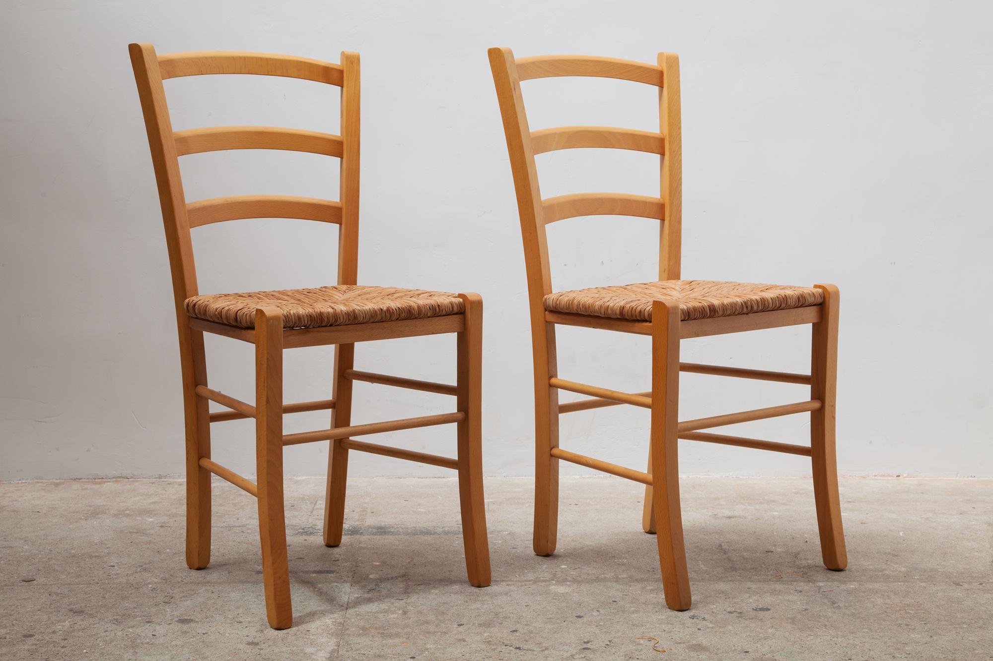Vintage midcentury chairs with solid wooden frames and woven rattan seats.