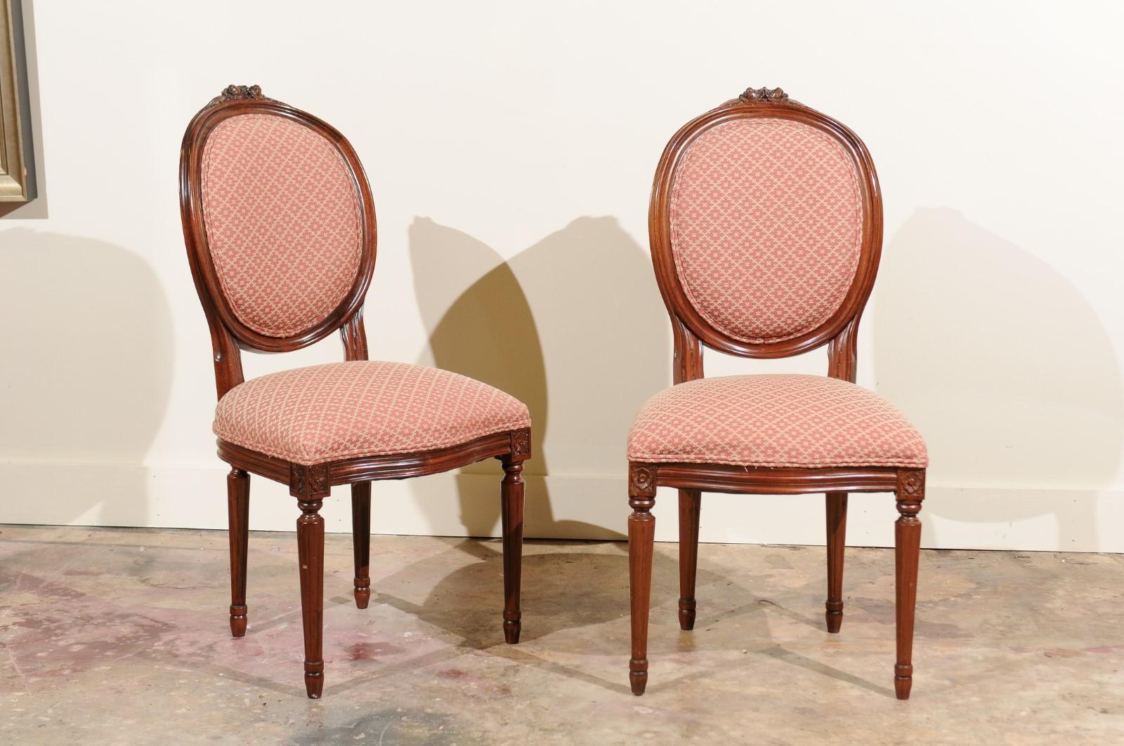 An elegant vintage set of Louis XVI carved oval back chairs. Fine carved detail on the arms. Rosette crest is above the four tapered and fluted legs.
The fabric is in good condition but one may want to update it. These chairs would look wonderful