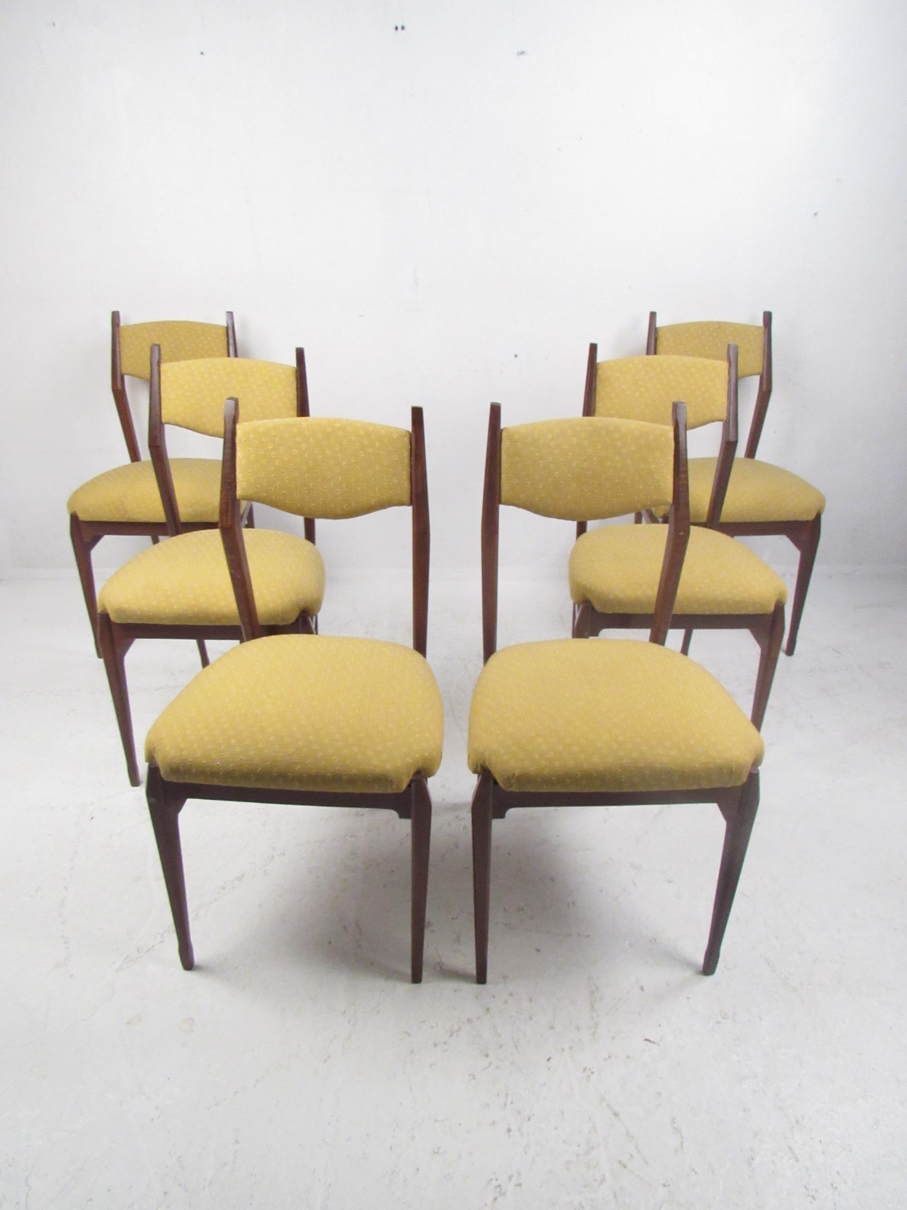 Elegant set of six Mid-Century Modern dining chairs with sculpted wood frames and floating backrests. A sleek and comfortable design that complements any seating arrangement. The thick padded seat and backrest are covered in decorative plush yellow