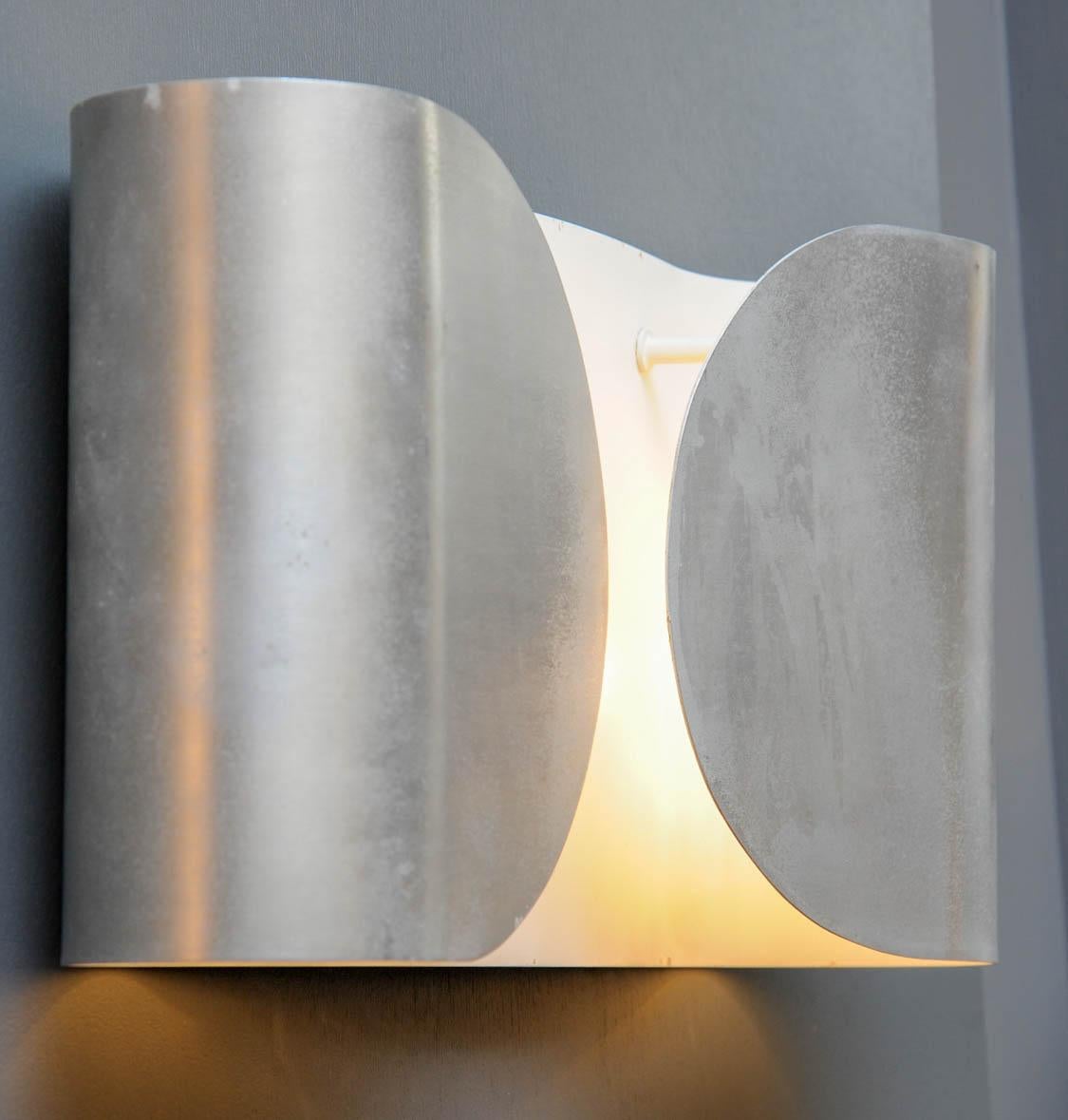 Elegant set of six wall sconces made of a single folded metal sheet holding two lights per sconce.
    