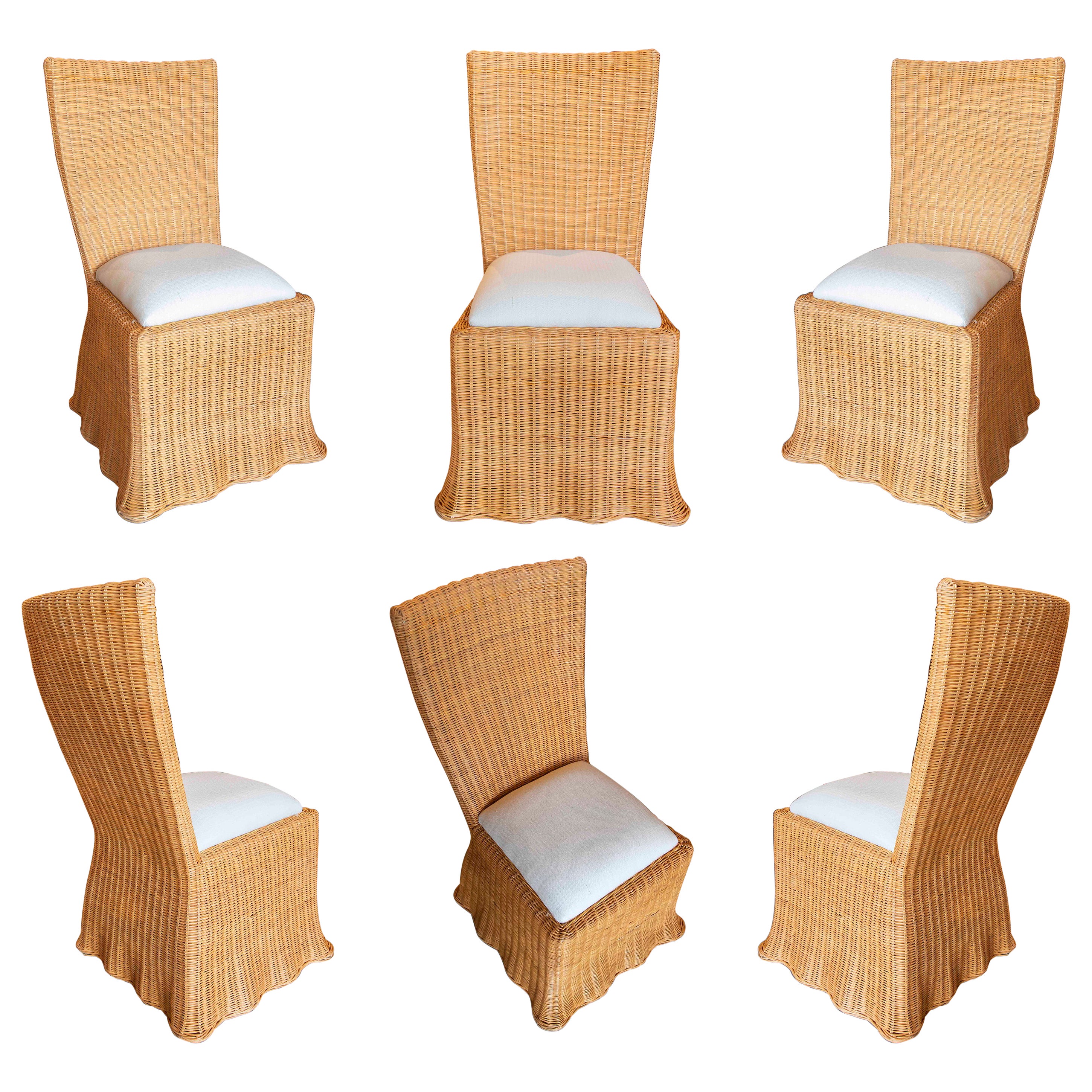 Conjunto de seis sillas de mimbre con formas onduladas y cojines beige