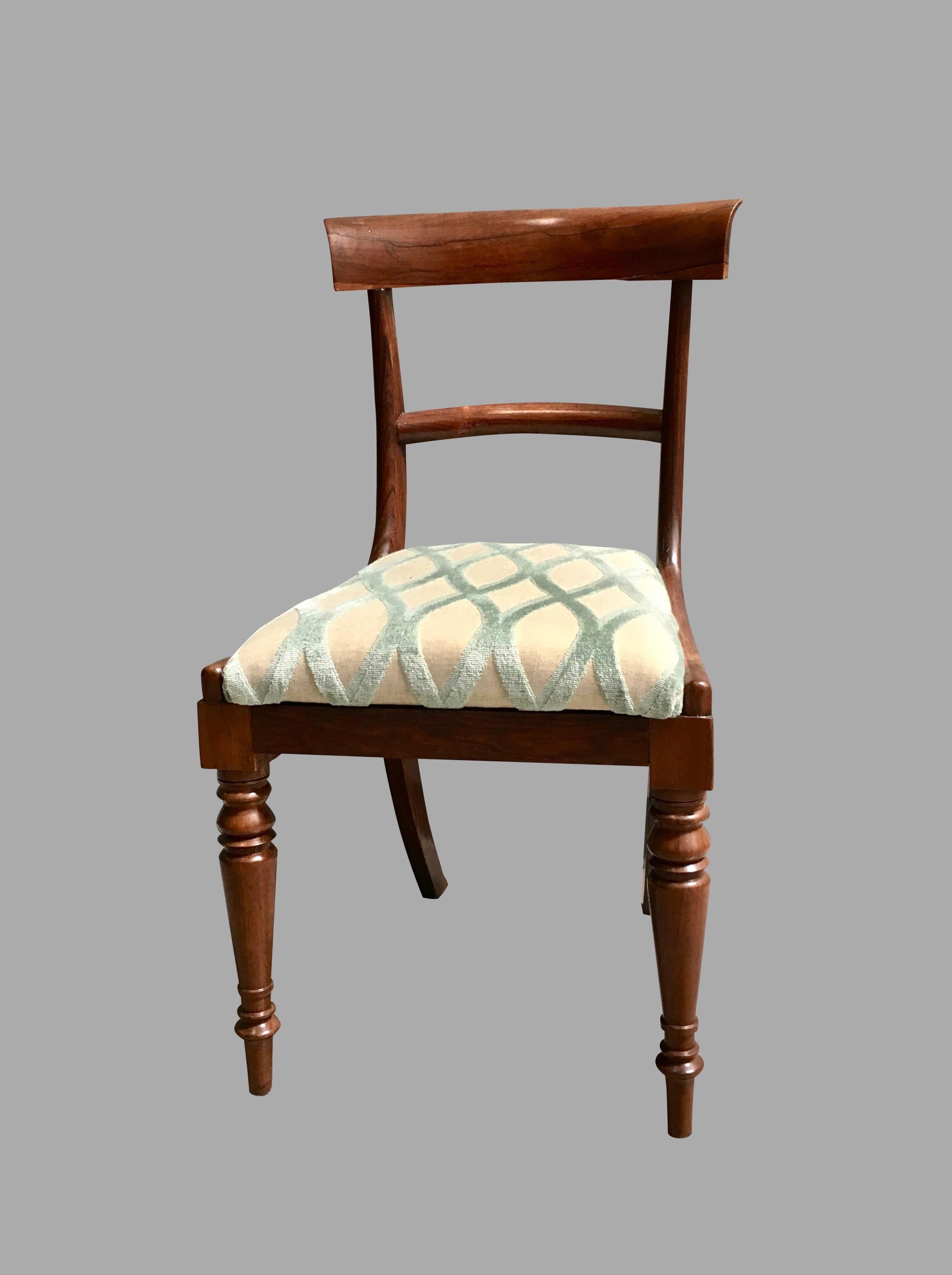 A set of six English William IV rosewood side chairs with slip seats, the curved chair rails above a simple horizontal back splat, the drop in seats above ring turned front and downswept back legs, circa 1835-1840.