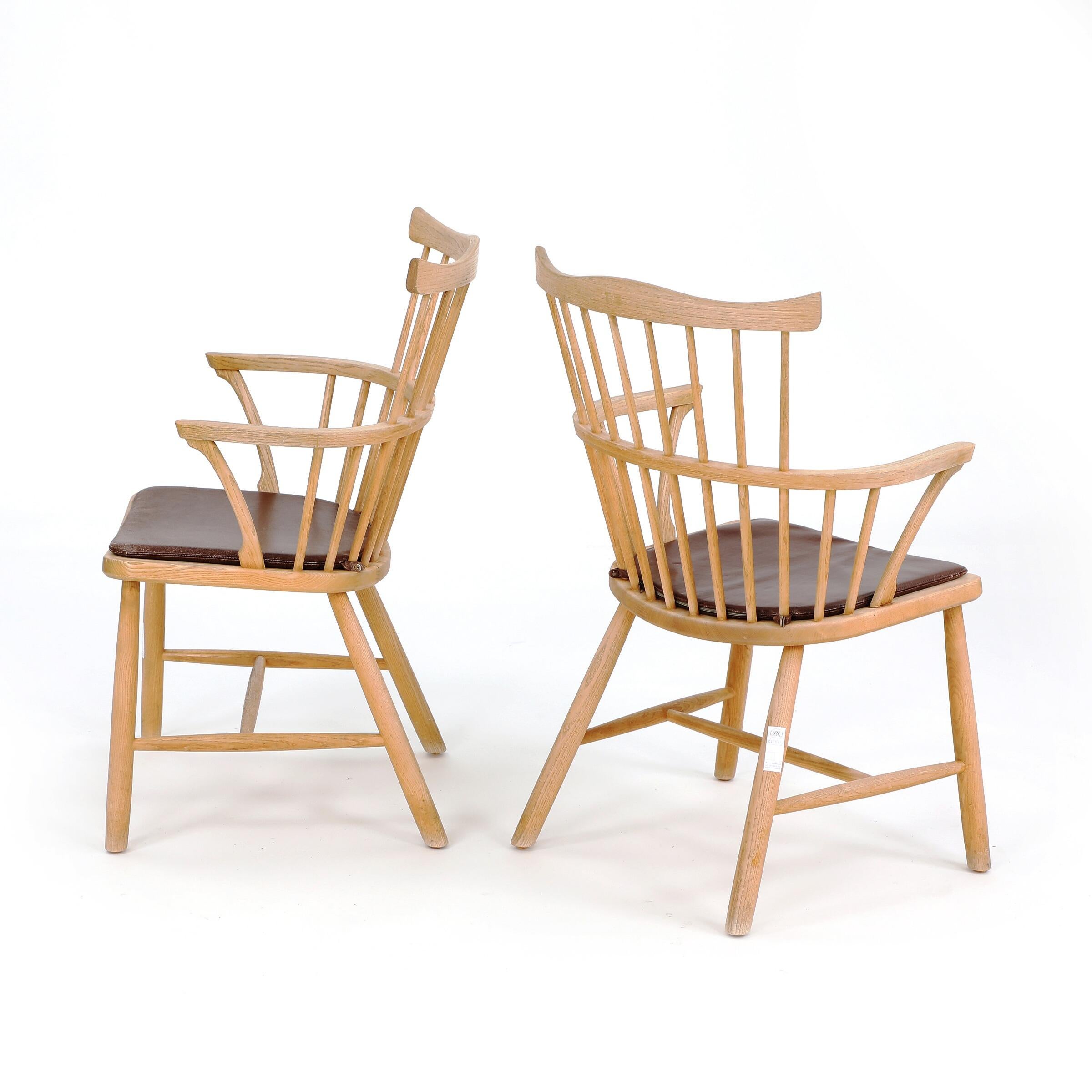 Set of six armchairs, Windsor style by Danish designer Børge Mogensen. Four of the chairs are in ash wood and two are in beech. Seat cushions upholstered with brown leather. Model J6 and model 3250. Designed 1944. Two chairs manufactured for FDB and